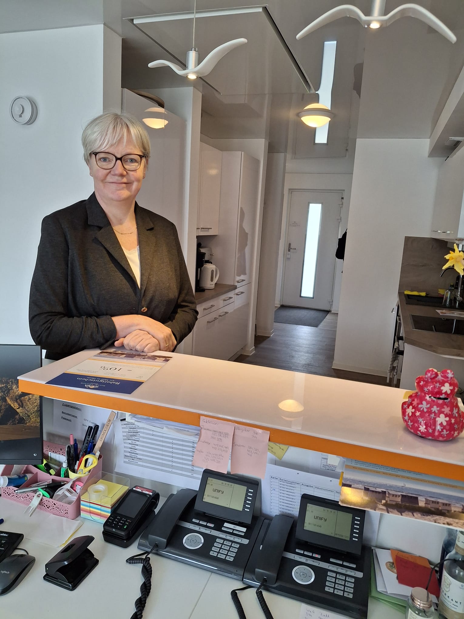 Ricci an einem Empfangstresen mit Telefonen und Bürobedarf, moderne Büroeinrichtung