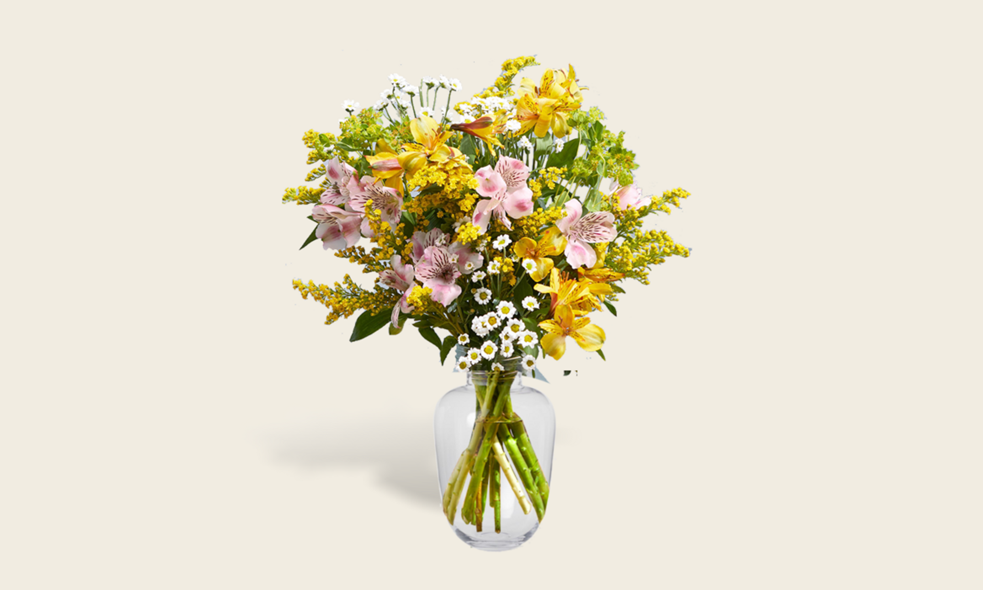 A bunch of yellow and pink flowers in a glass vase