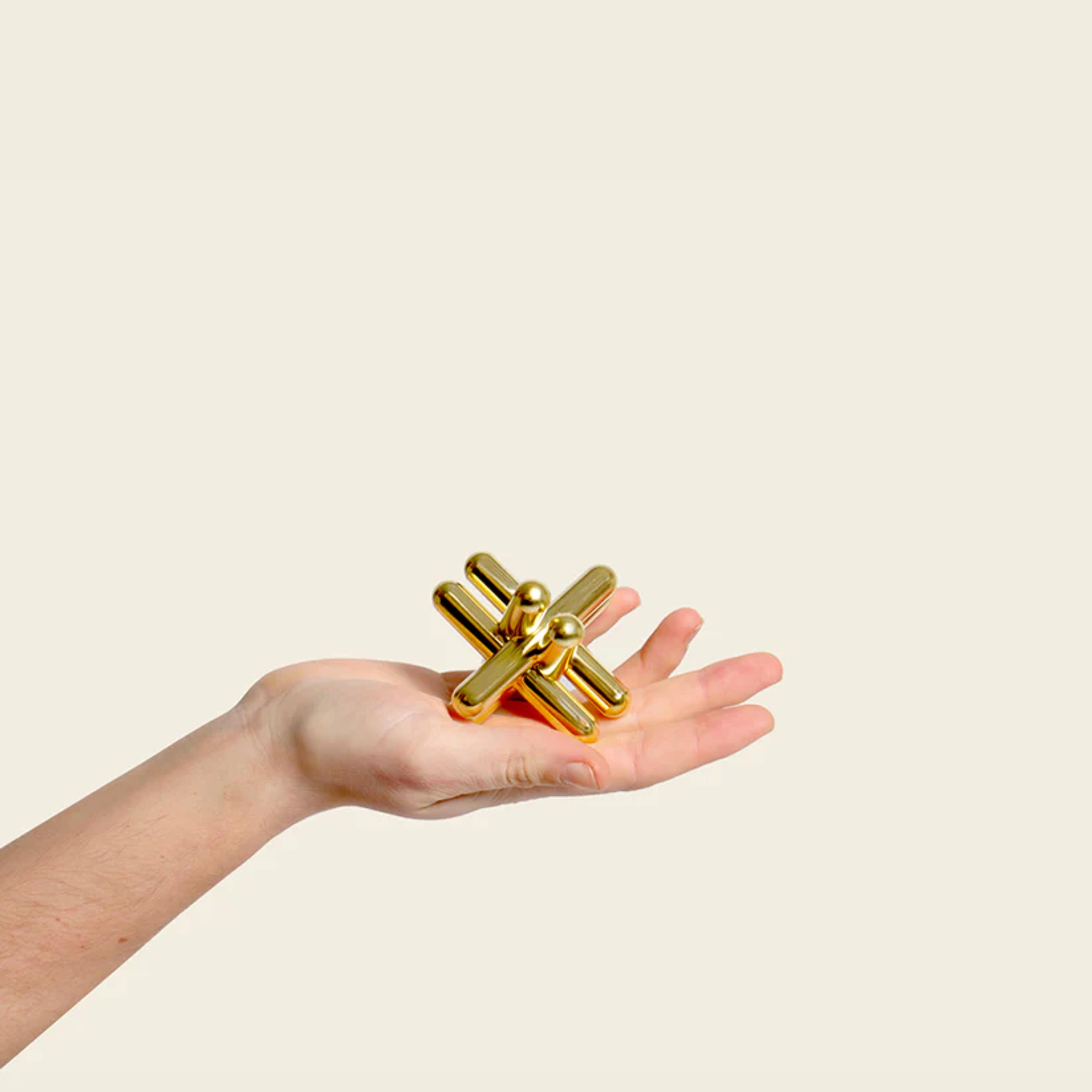 A hand holding a gold puzzle piece