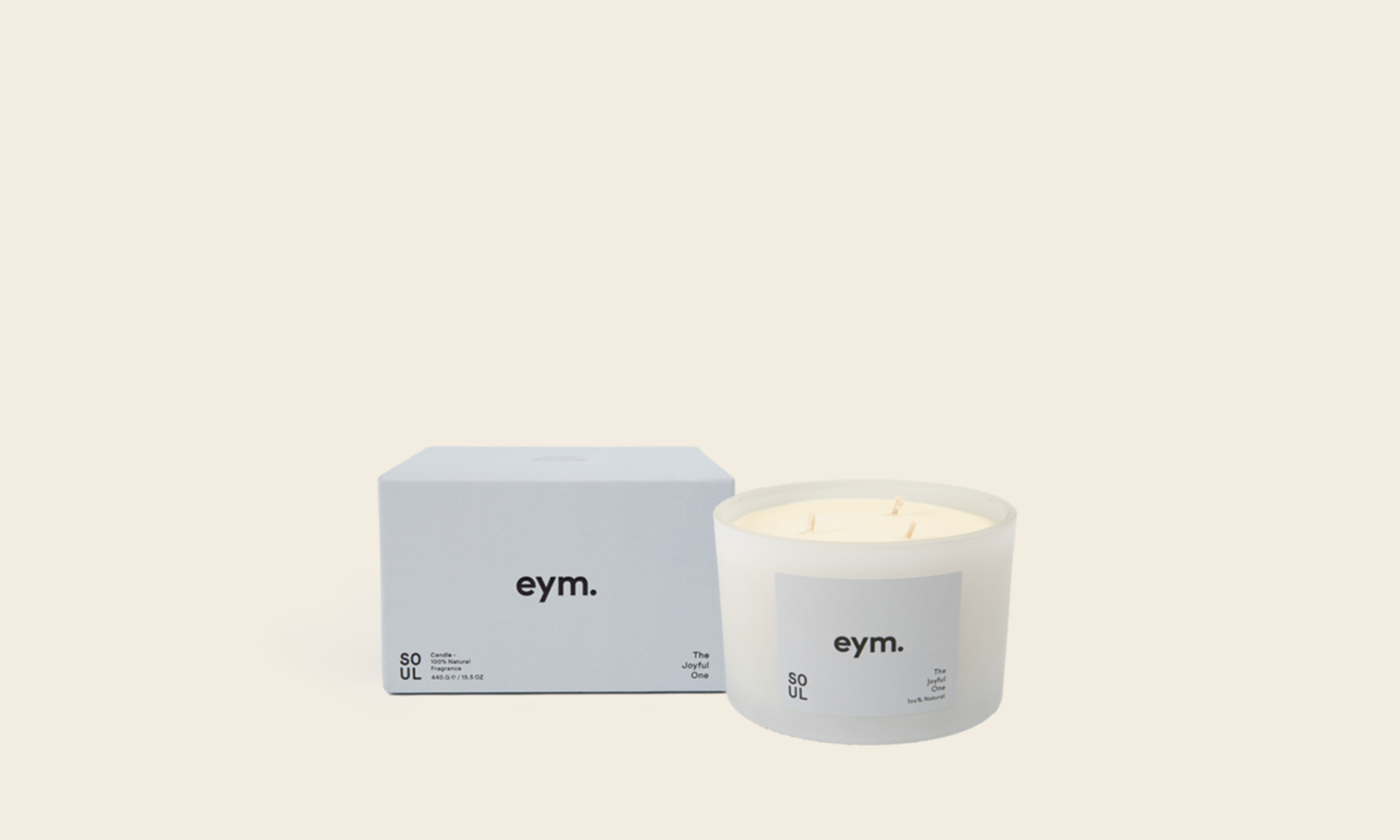 A white Eym candle with three wicks beside the packaging 