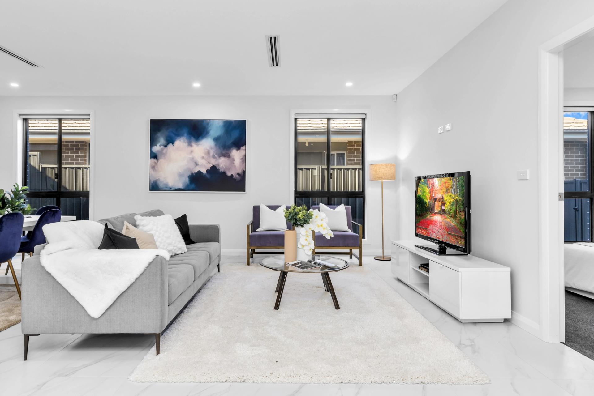 open plan living room with white walls, downlights and furniture set up, built by Balwin Homes