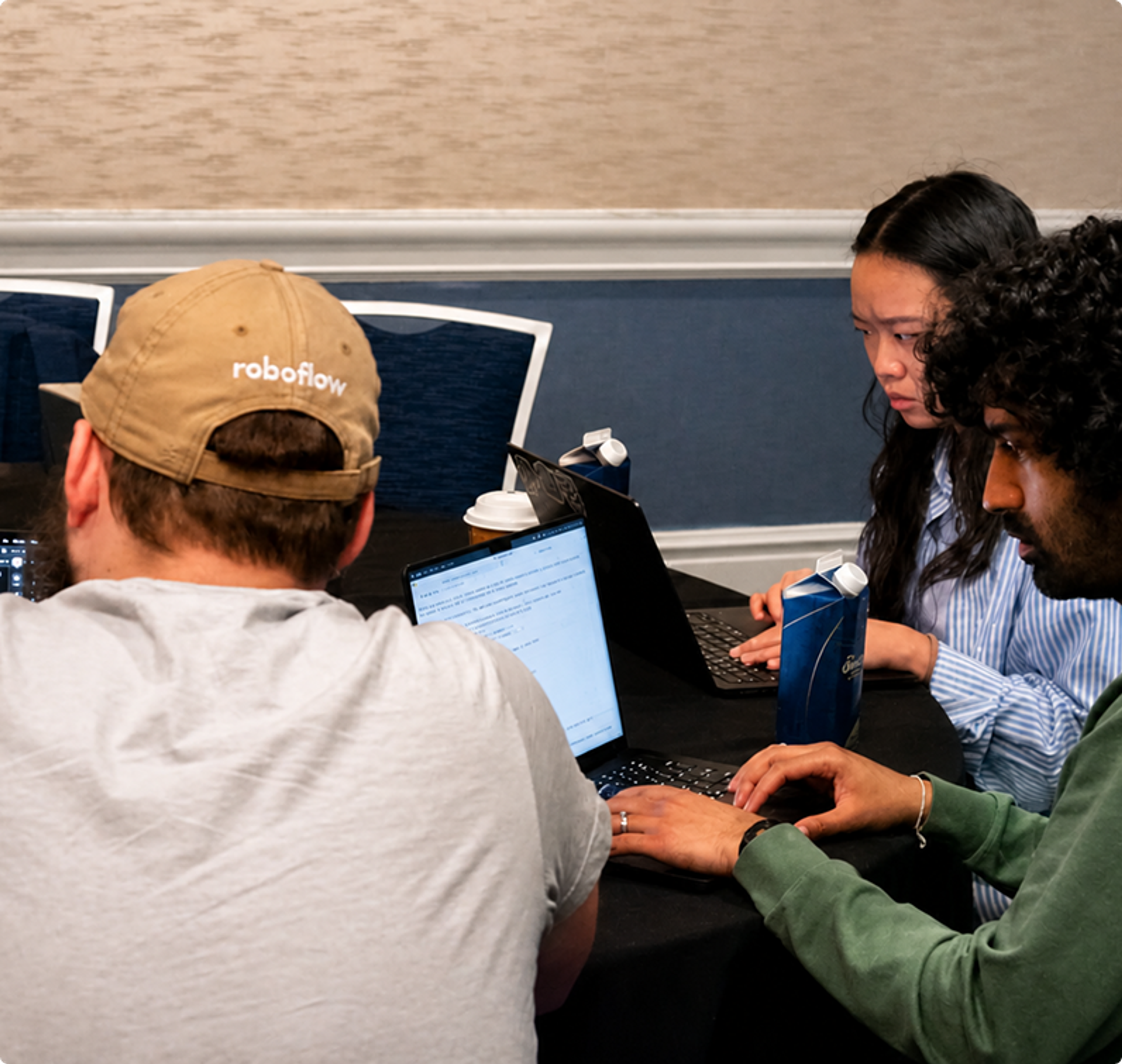 Three people focused on laptops at a table.