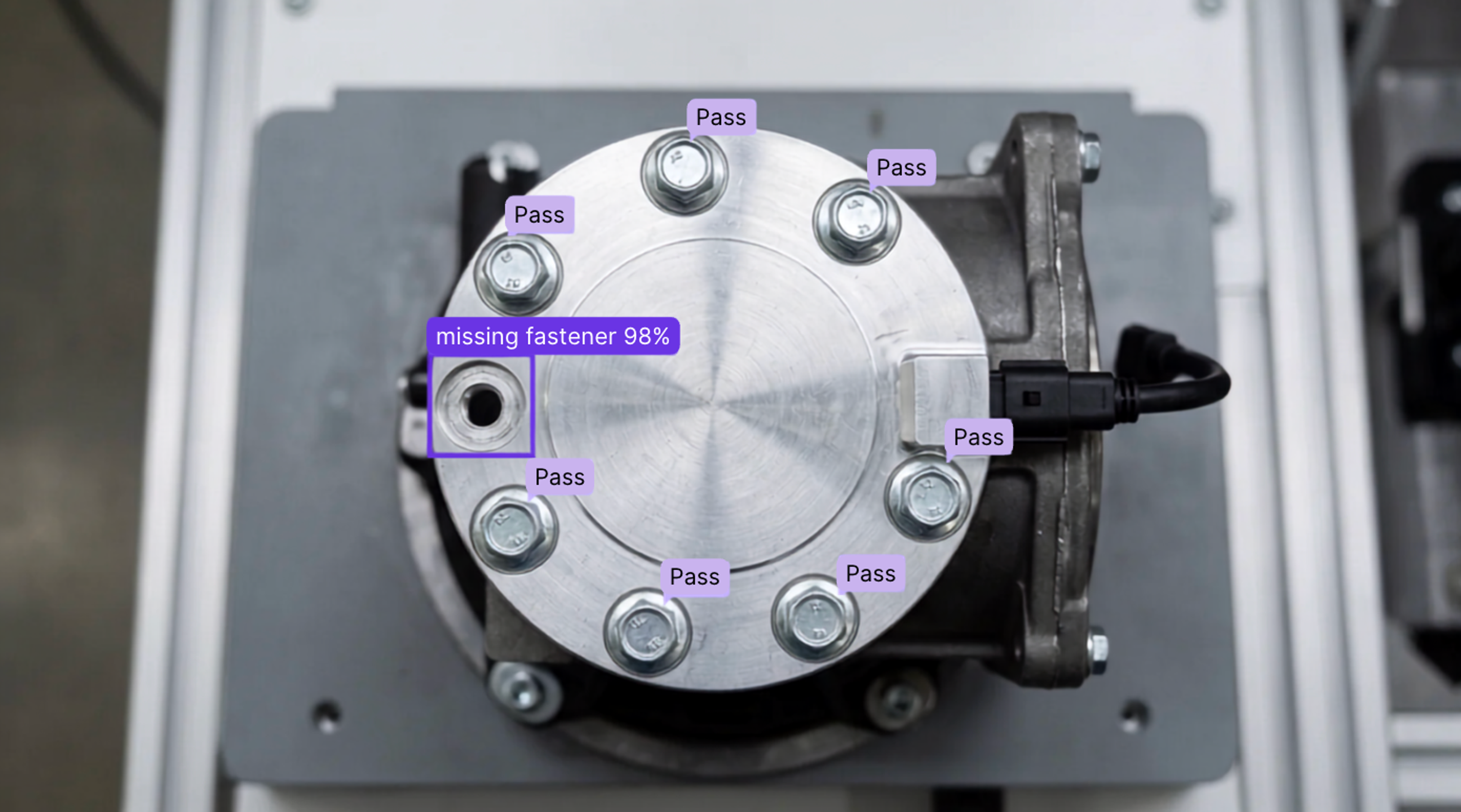 A bolted flange seen from above: seven fasteners pass and one missing fastener is flagged at 98% confidence
