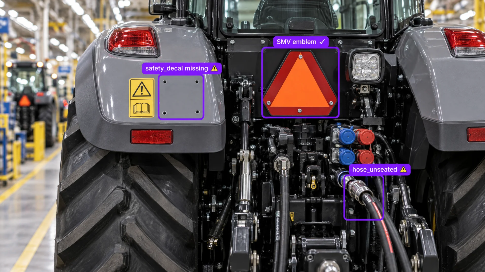 Rear view of a grey tractor highlighting a missing safety decal and an unseated hydraulic hose.
