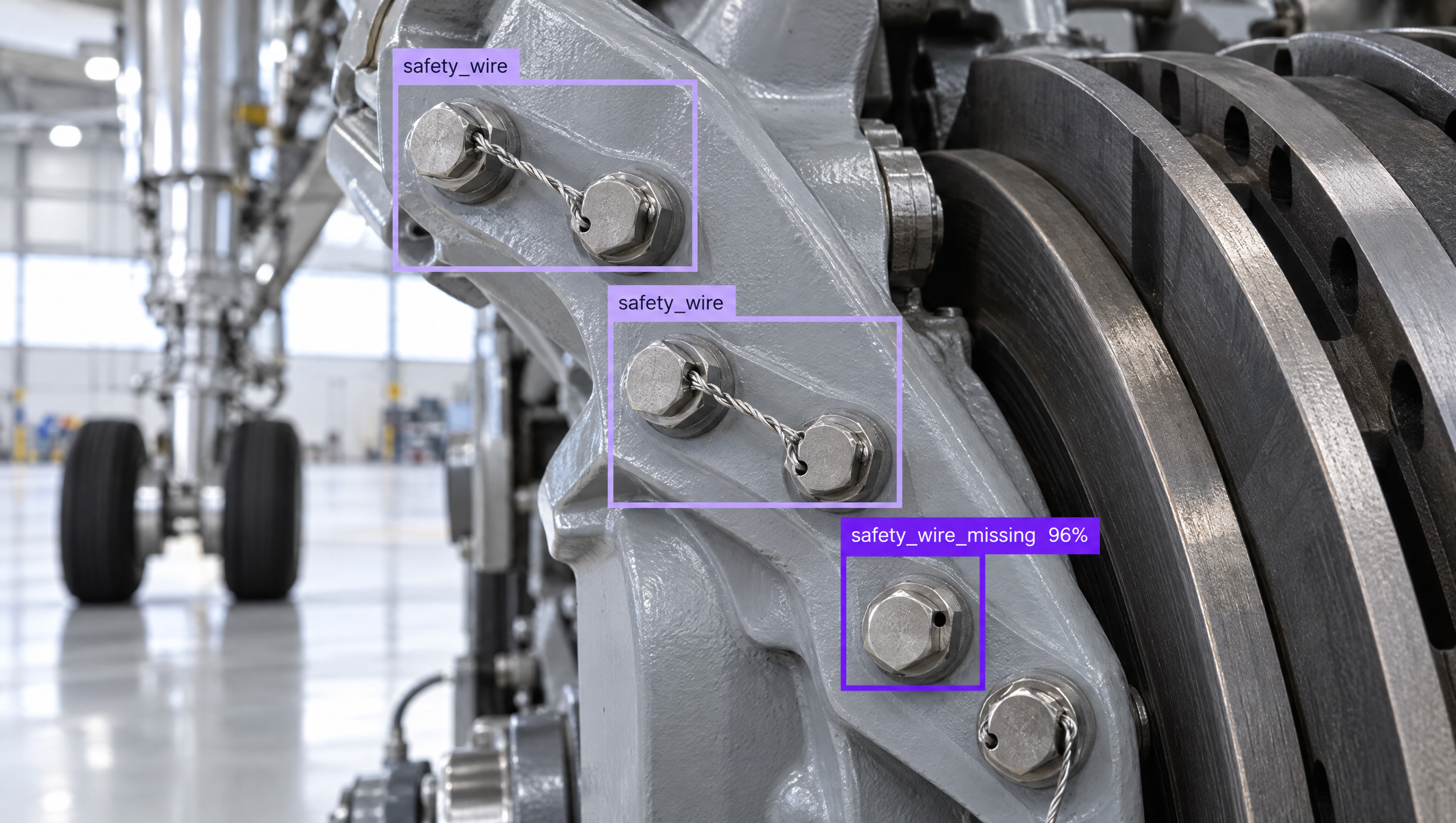 Close-up of airplane landing gear bolts with AI object detection showing "safety_wire" on two and "safety_wire_missing" on one.