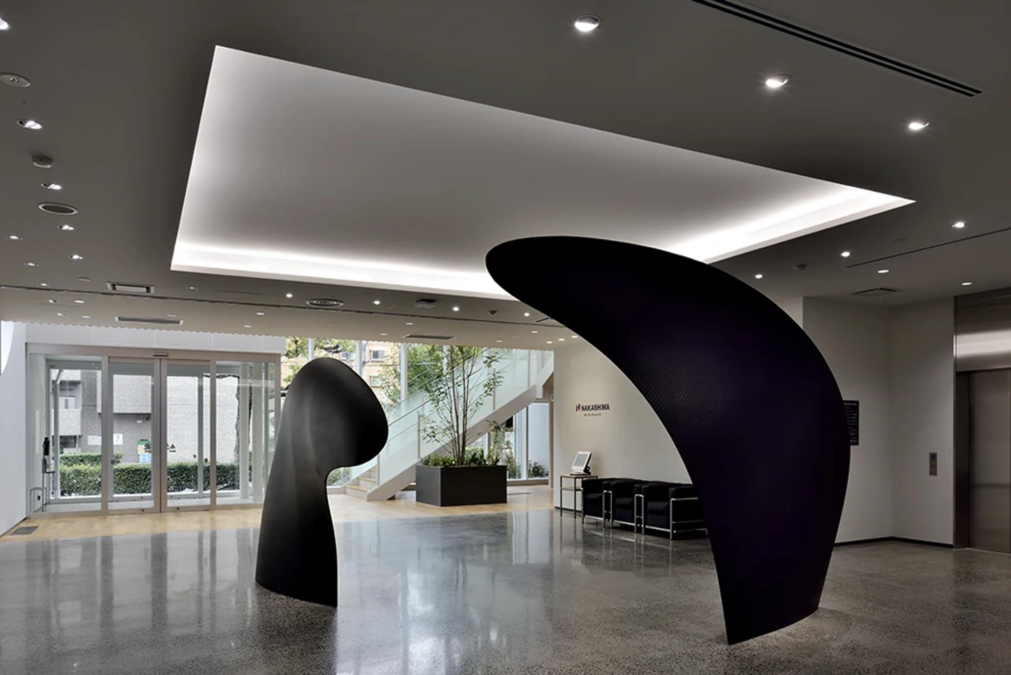 Two large black carbon fiber propeller blades displayed as sculpture in the Nakashima Propeller lobby.
