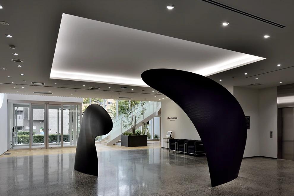 Two large black carbon fiber propeller blades displayed as sculpture in the Nakashima Propeller lobby.