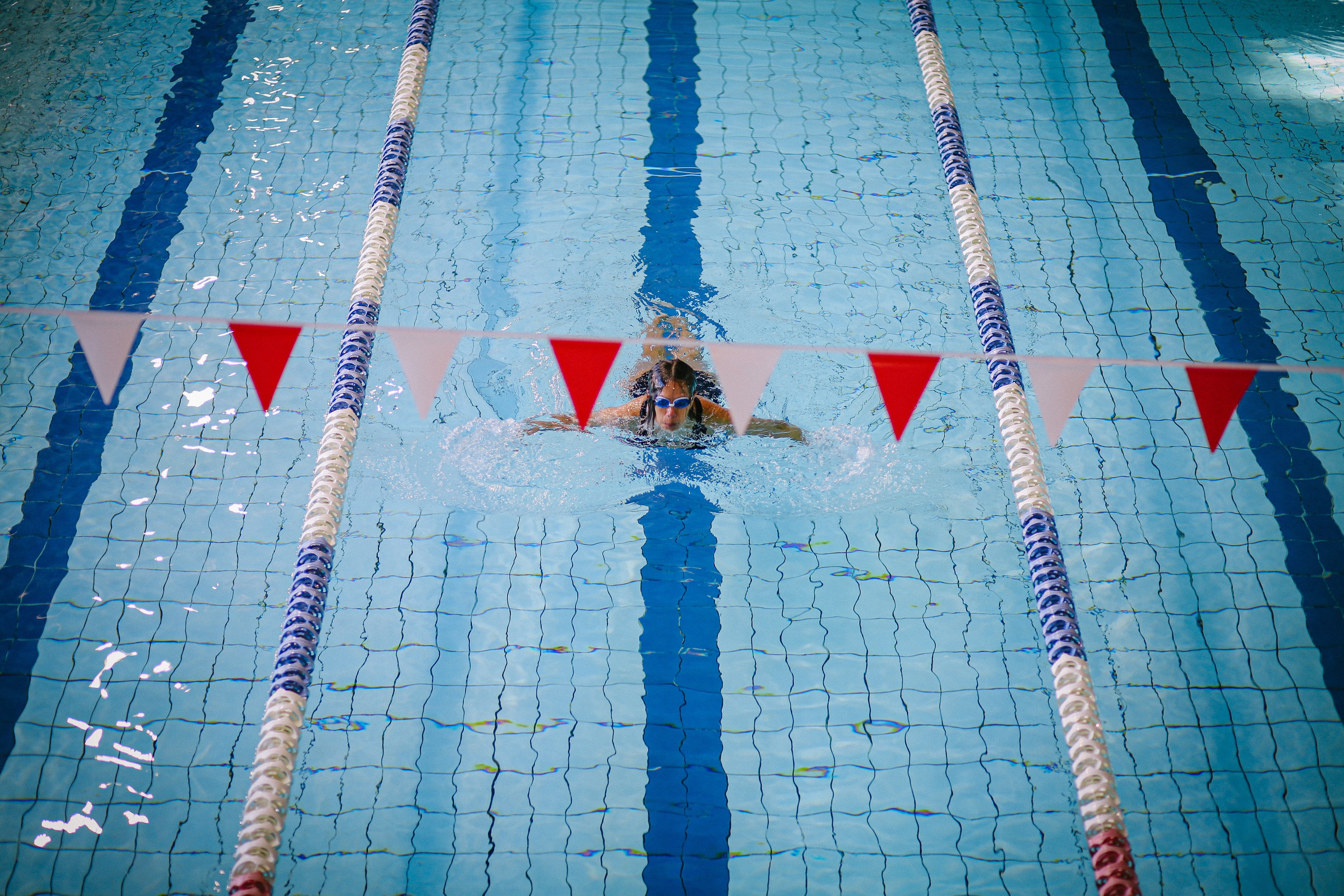 Woman with goggles swimming laps at Cook + Phillip Park pool