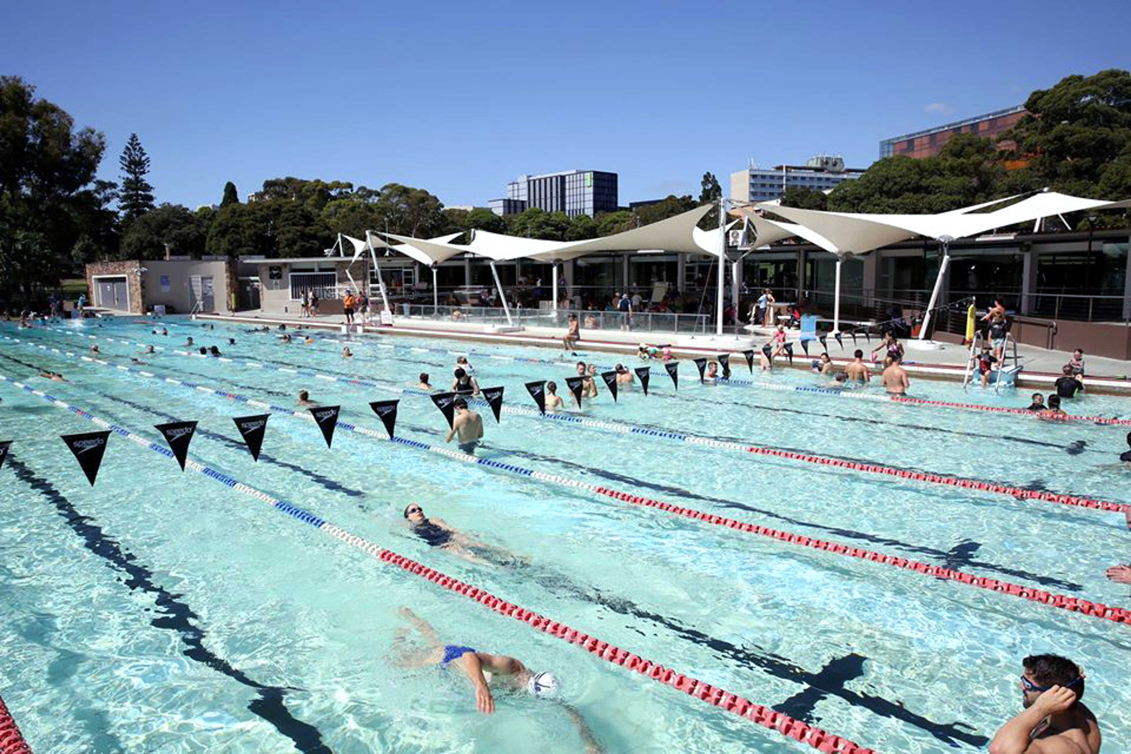 People swimming in the outdoor pool at Victoria Park Pool