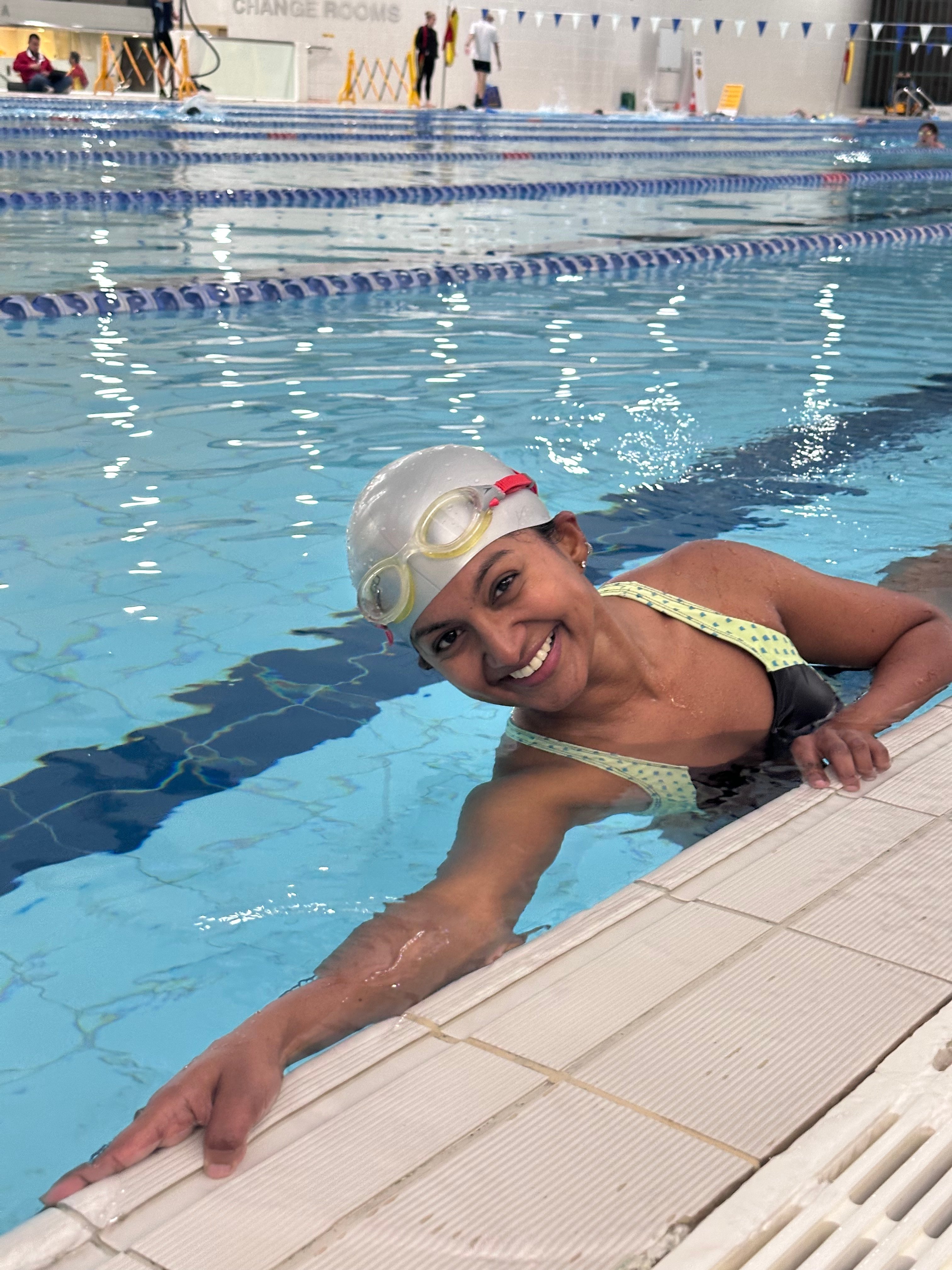 Learn to Swim participant Swapna smiling in the pool at Ian Thorpe Aquatic Centre