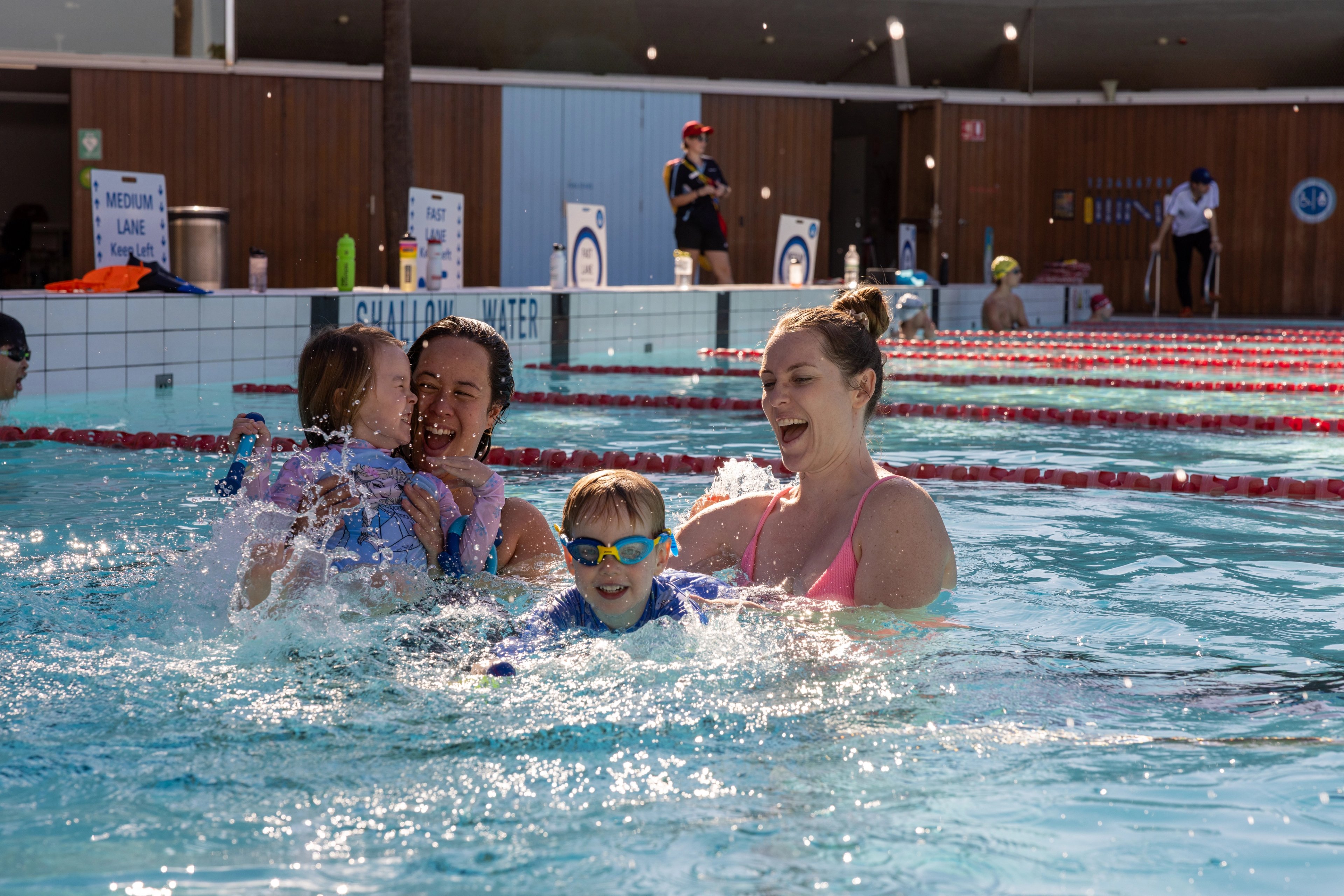 Two women and two kids splashing in the outdoor pool at Prince Alfred Park Pool