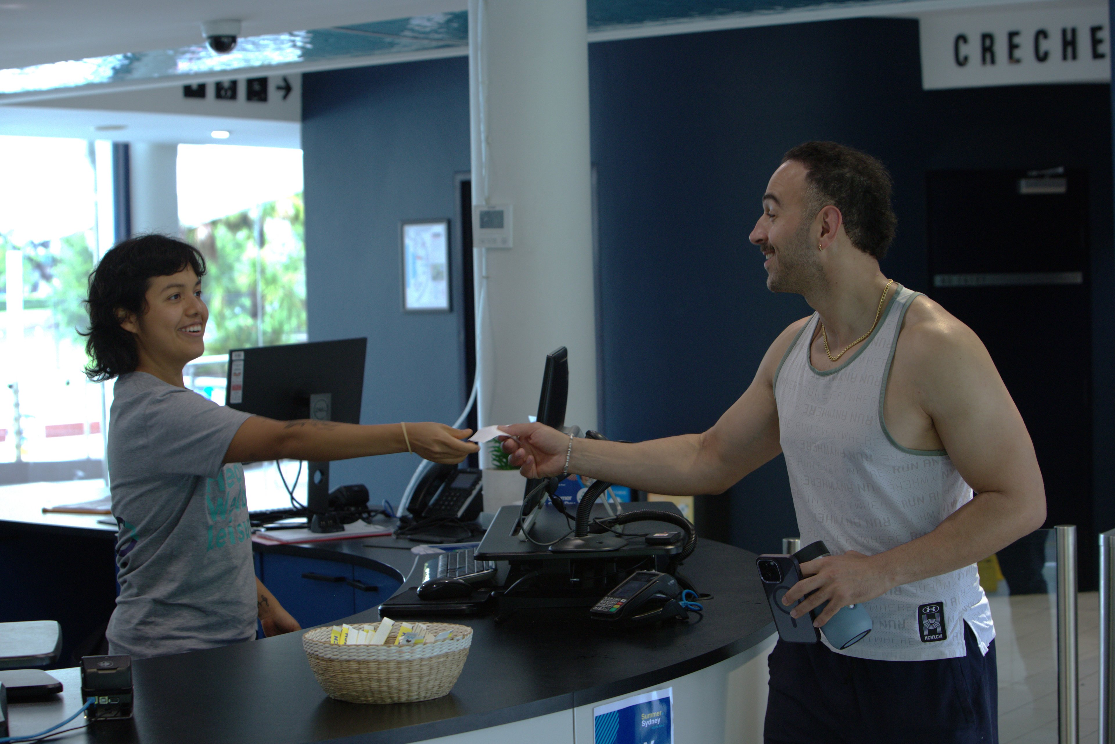 A member being served at the reception desk at Victoria Park Pool