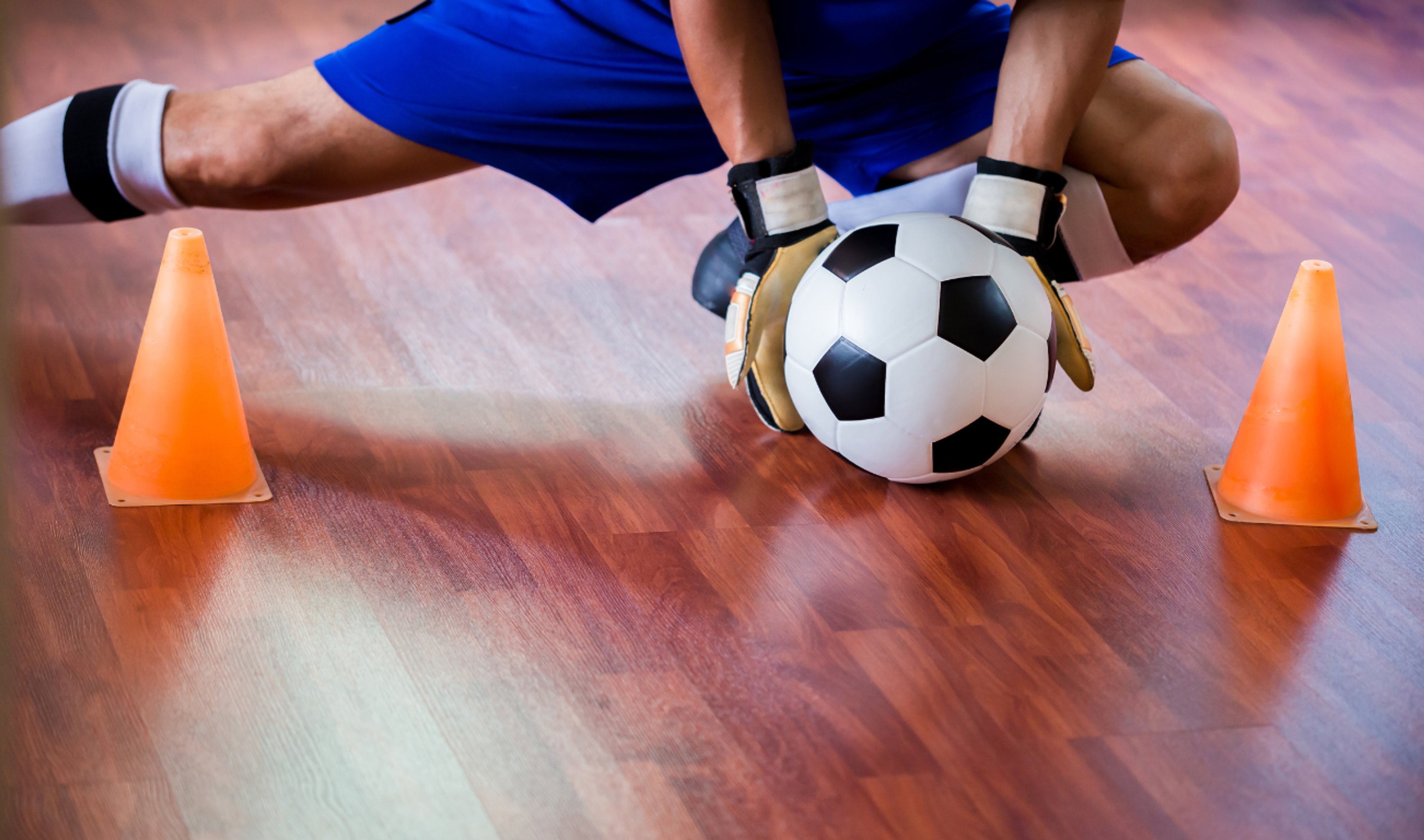 Man catching a ball during a game of futsal 