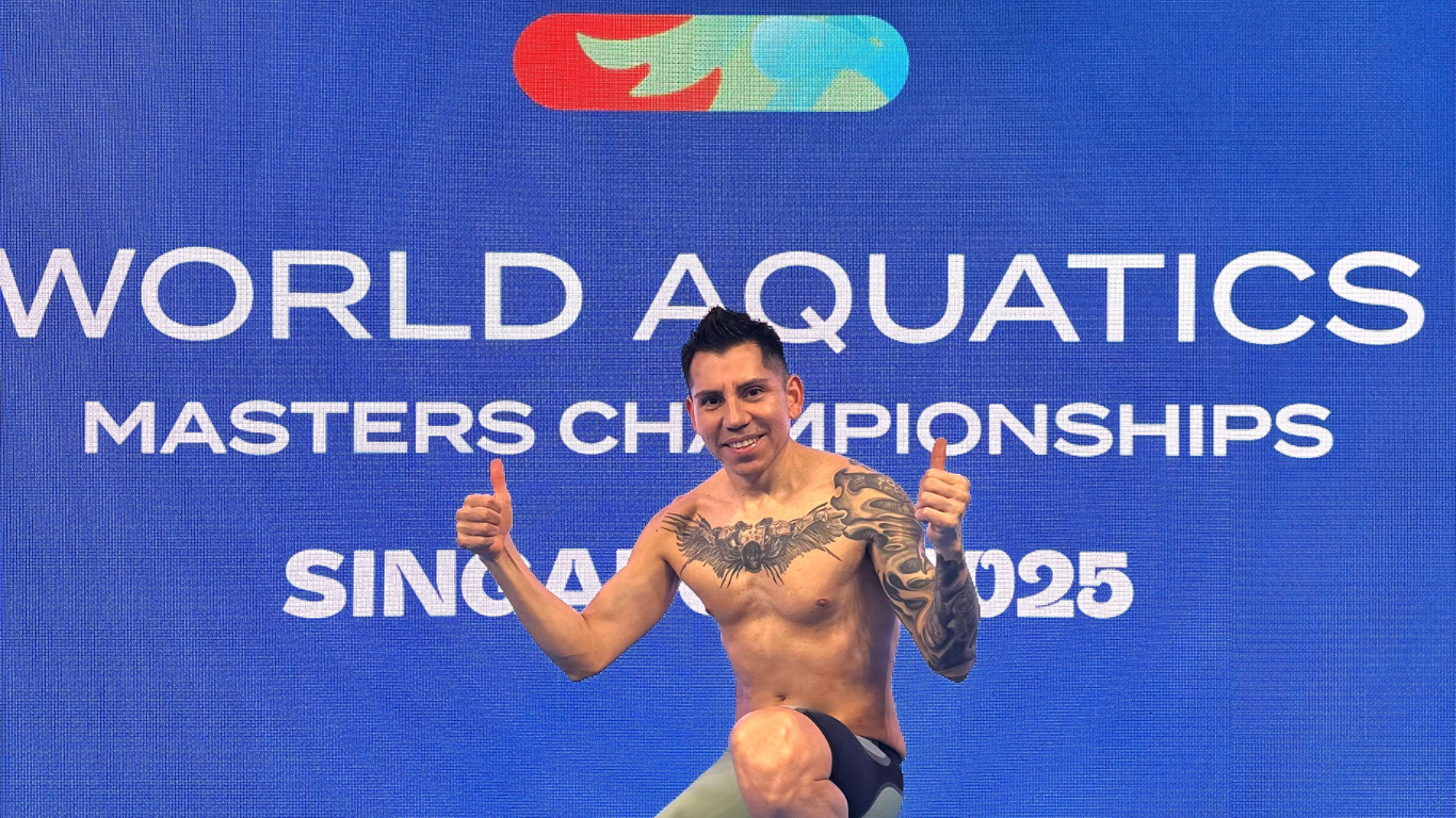 Socrates posing with his thumbs up in front of the World Aquatics screen