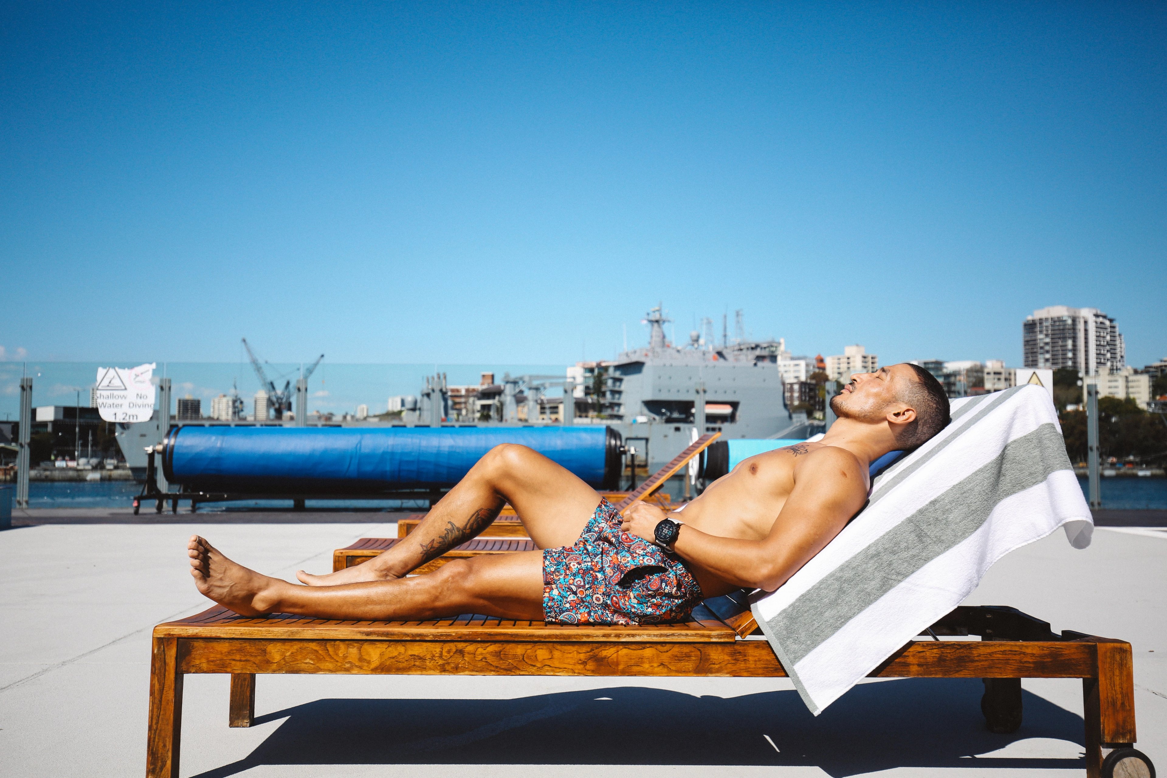 Man lying on a sun lounger at Andrew (Boy) Charlton Pool