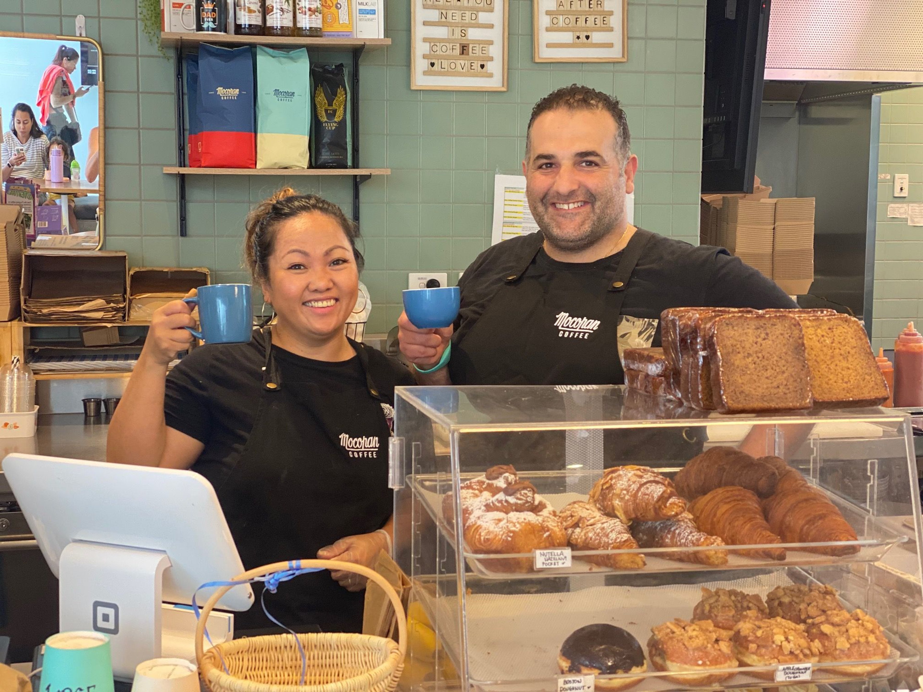 Cafe staff standing behind the counter and smiling at Gunyama Park Cafe 