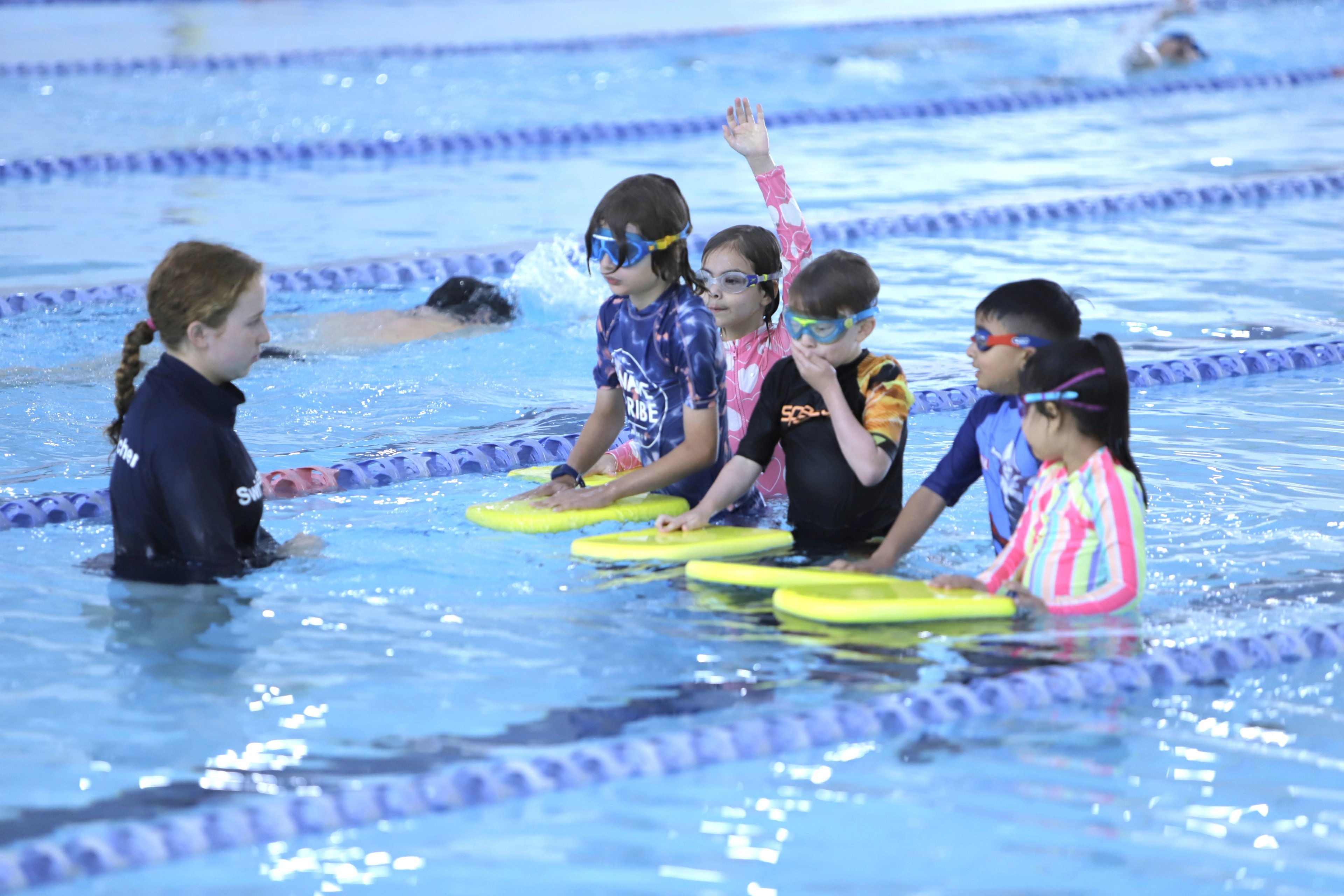 A swim teacher with a group of Learn to Swim participants in the pool at Ian Thorpe Aquatic Centre