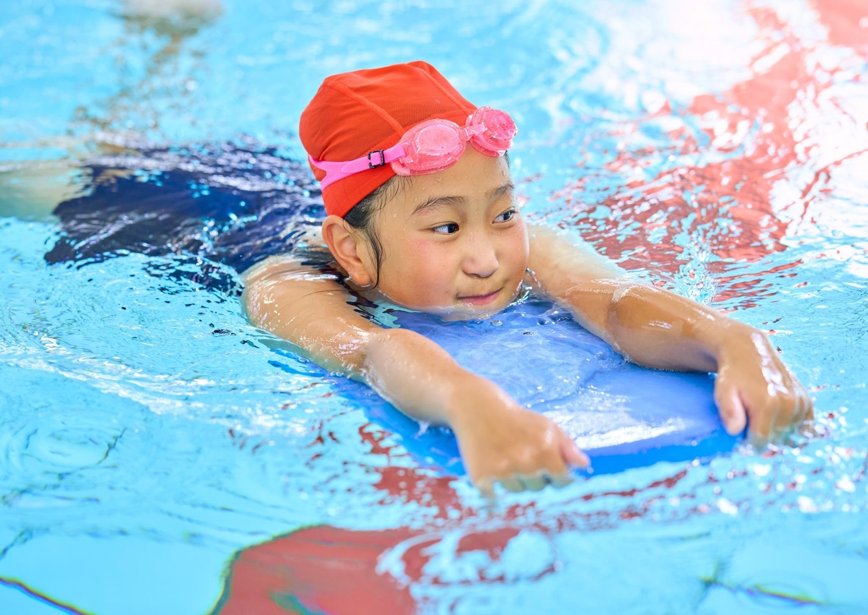Child using a kickboard while swimming in the pool