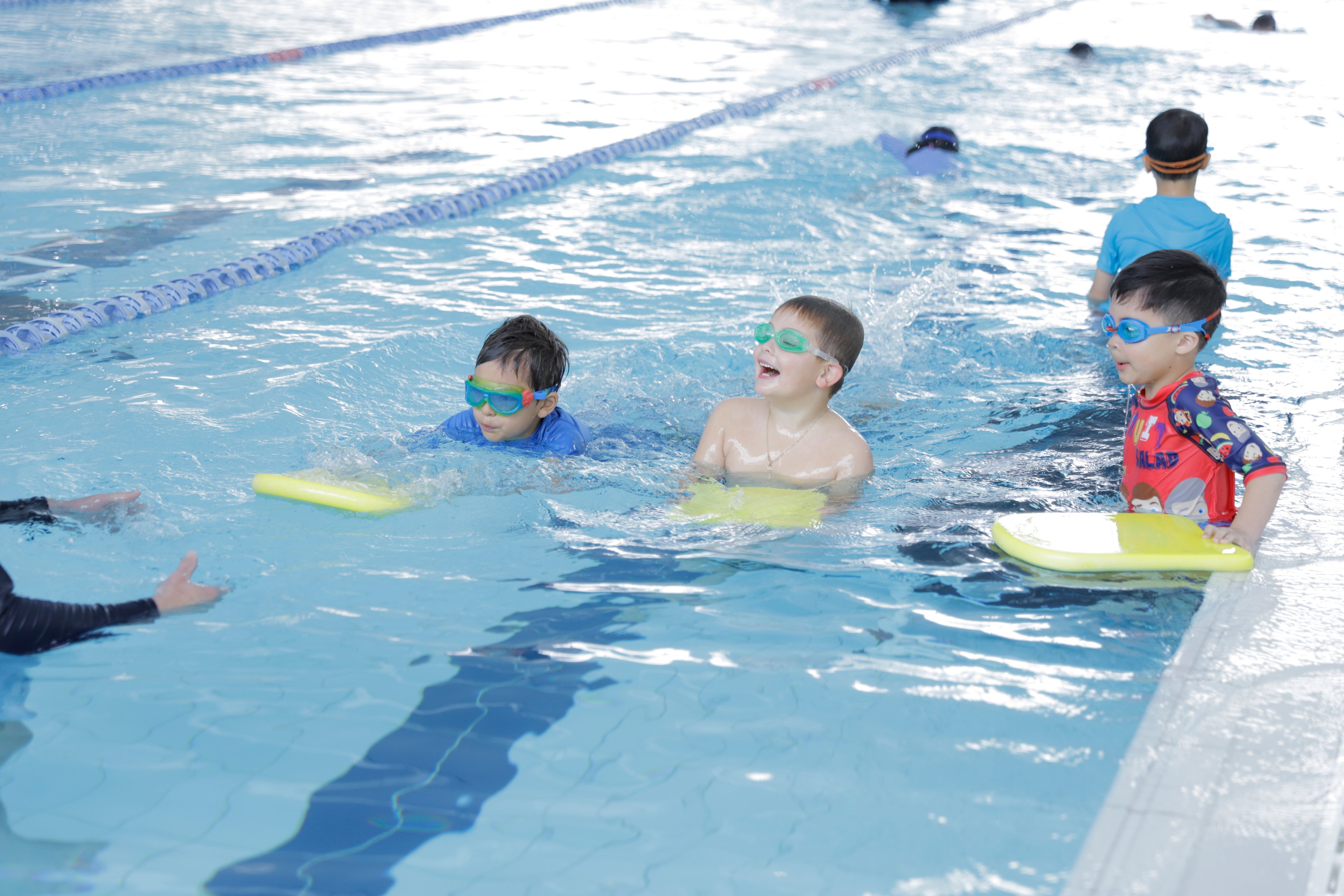 Three children in the Gunyama Park pool during a learn to swim lesson