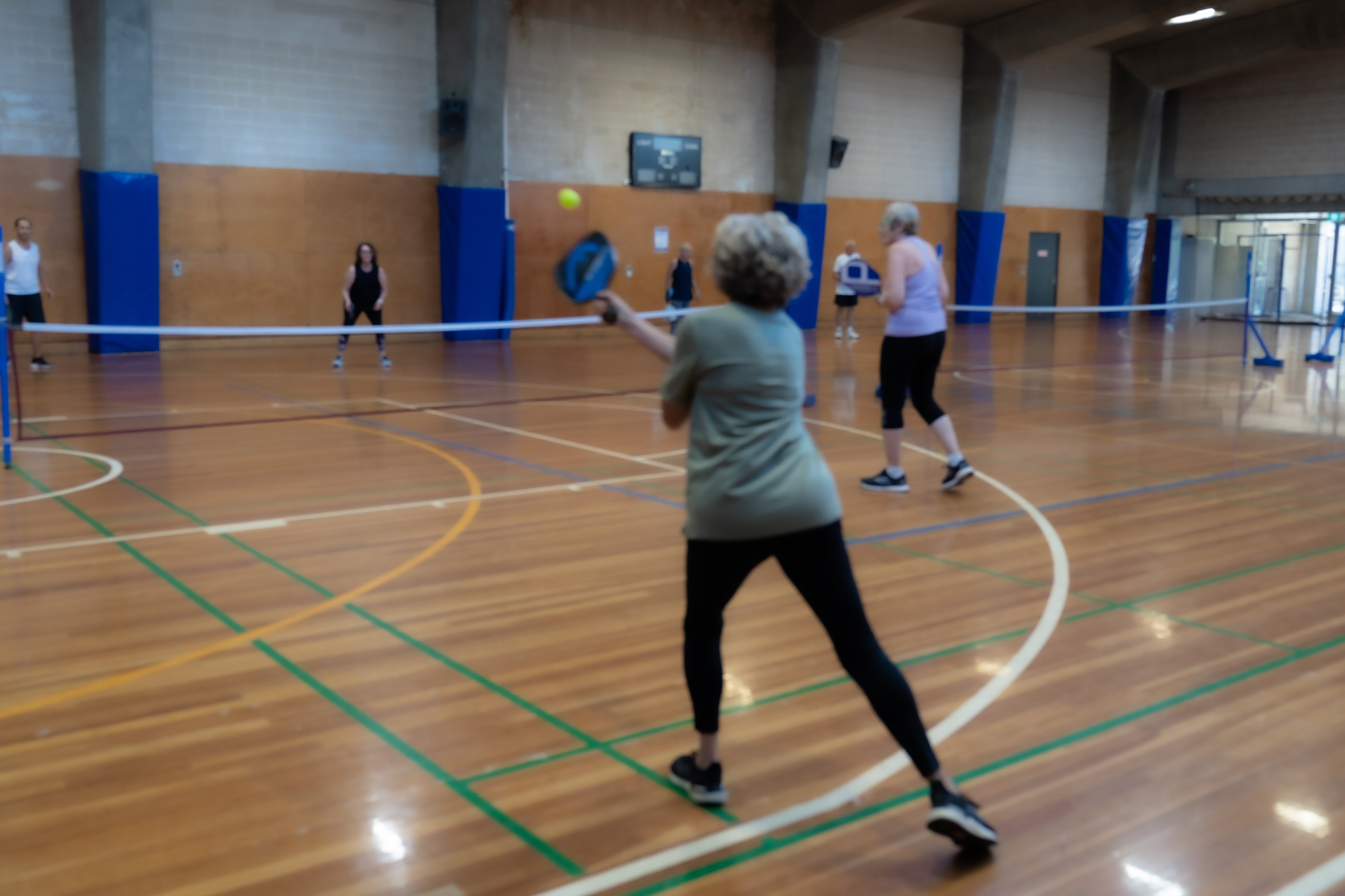 A group playing a game of pickleball at Cook + Phillip Park Pool sports court