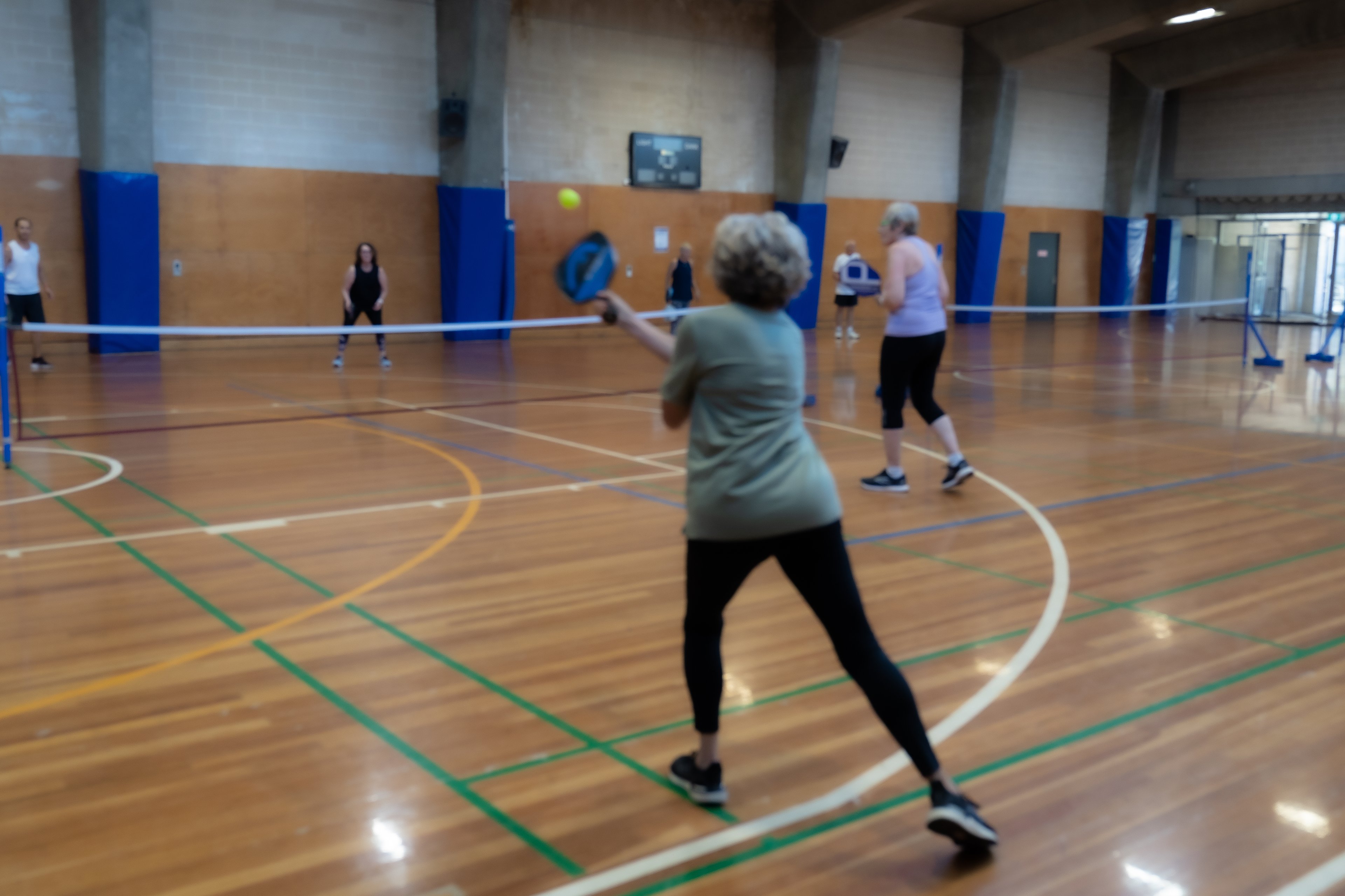 A group playing a game of pickleball at Cook + Phillip Park Pool sports court 