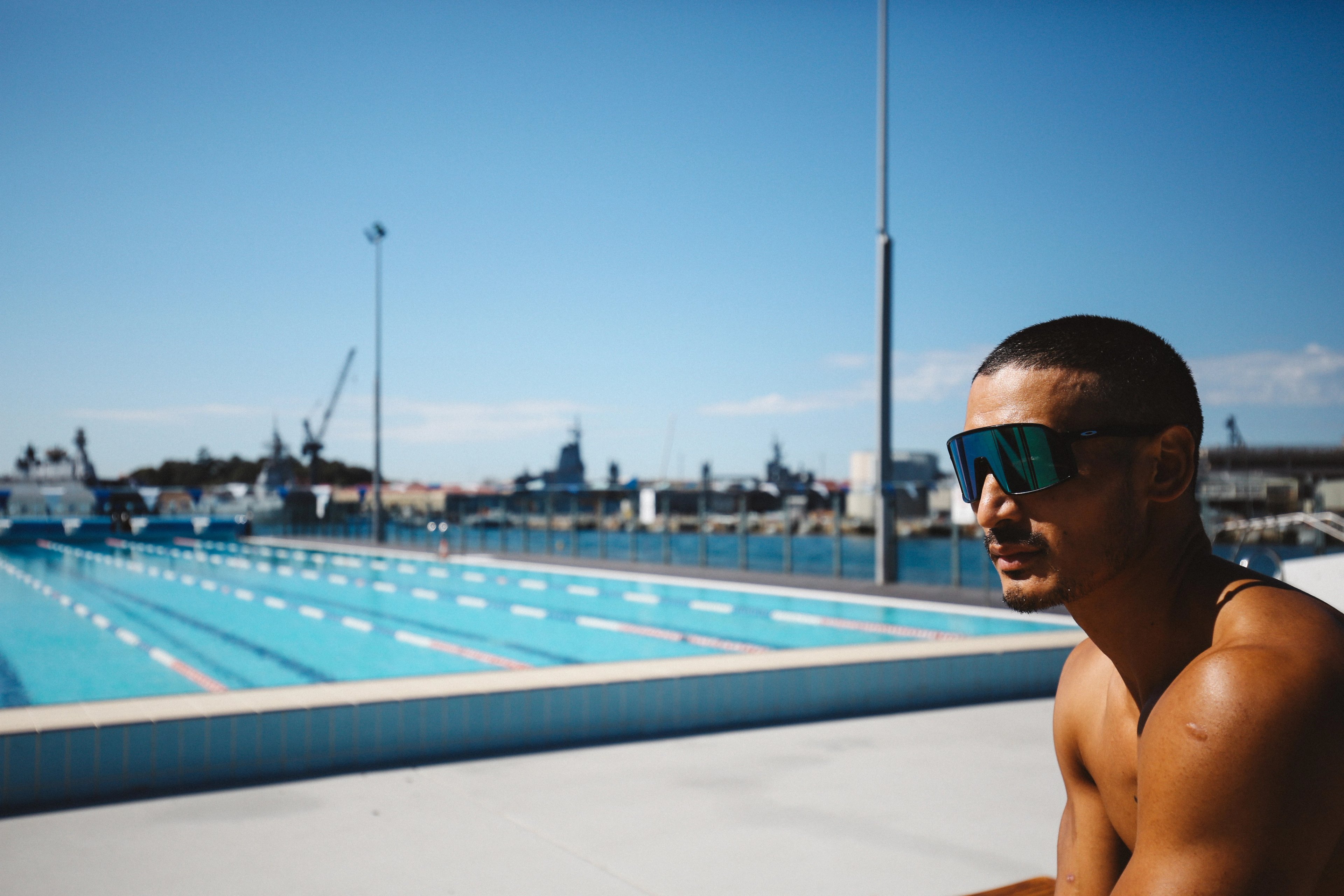 Male wearing sunglasses enjoying the sun on the pool deck of Andrew (Boy) Charlton Pool