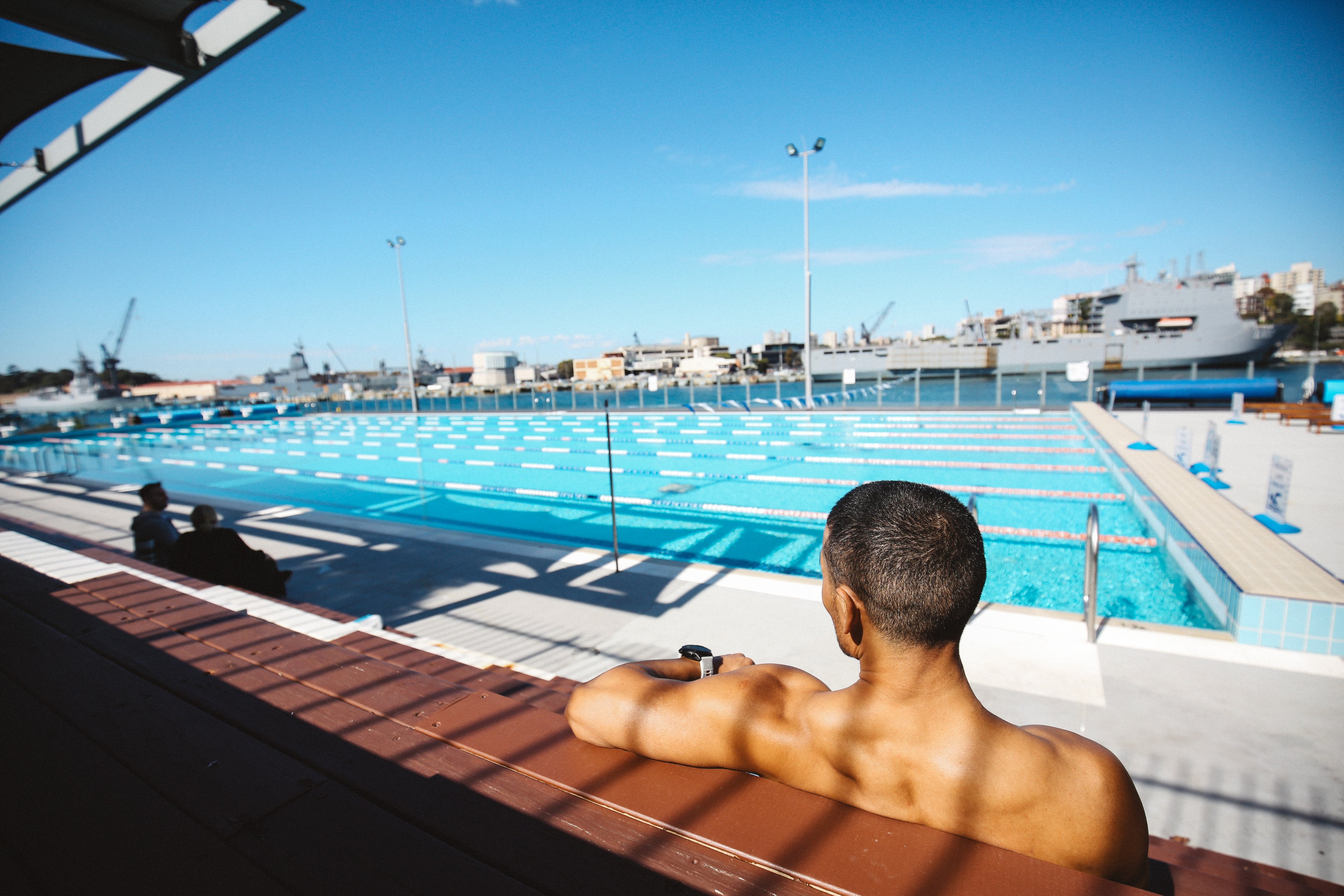 Male sitting and looking over at Andrew (Boy) Charlton Pool