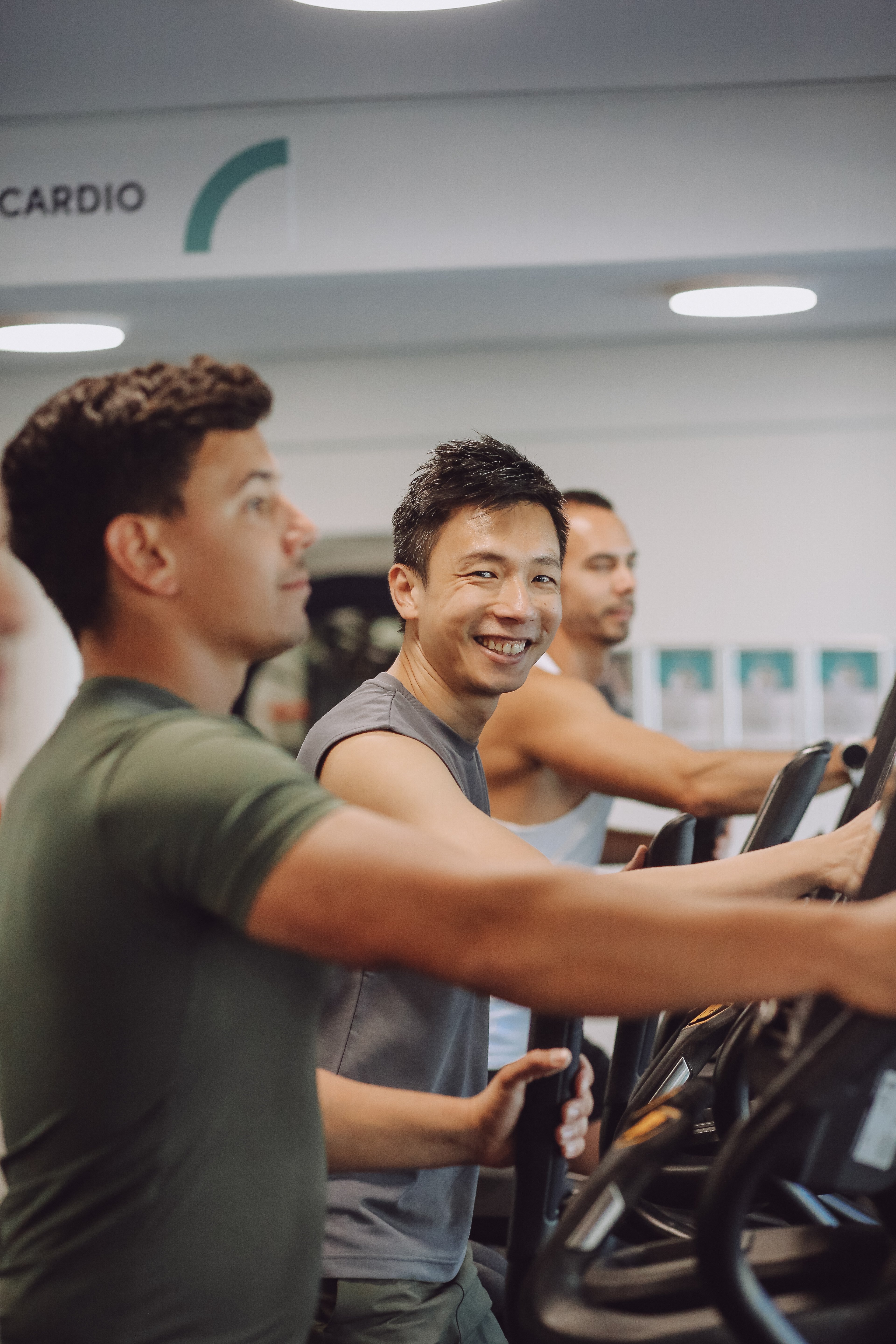 Group of friends working out on cross-trainer machines in the fitness centre at Victoria Park Pool