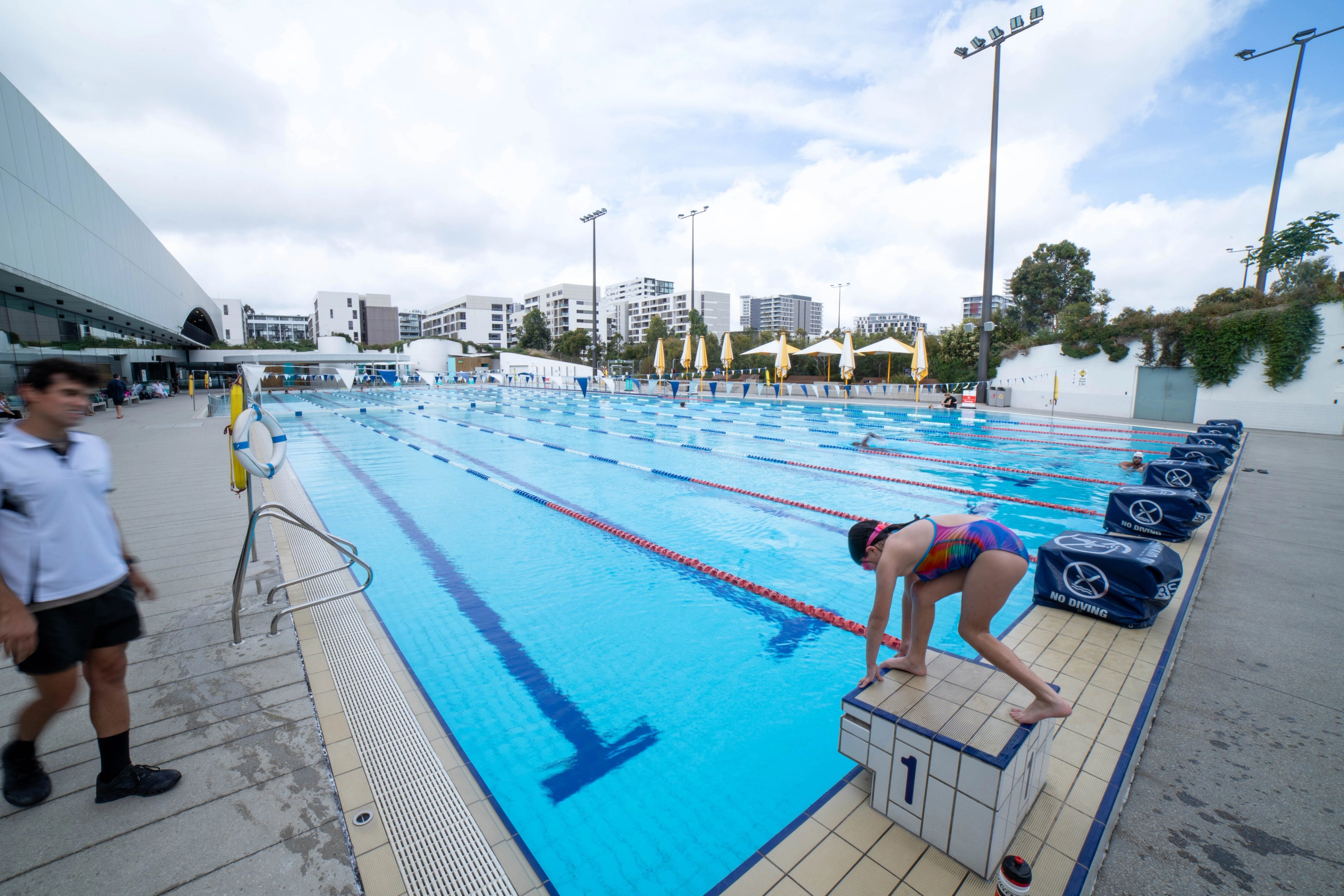 Young girl on the diving platform, about to dive into the 50m pool at Gunyama Park Aquatic and Recreation Centre