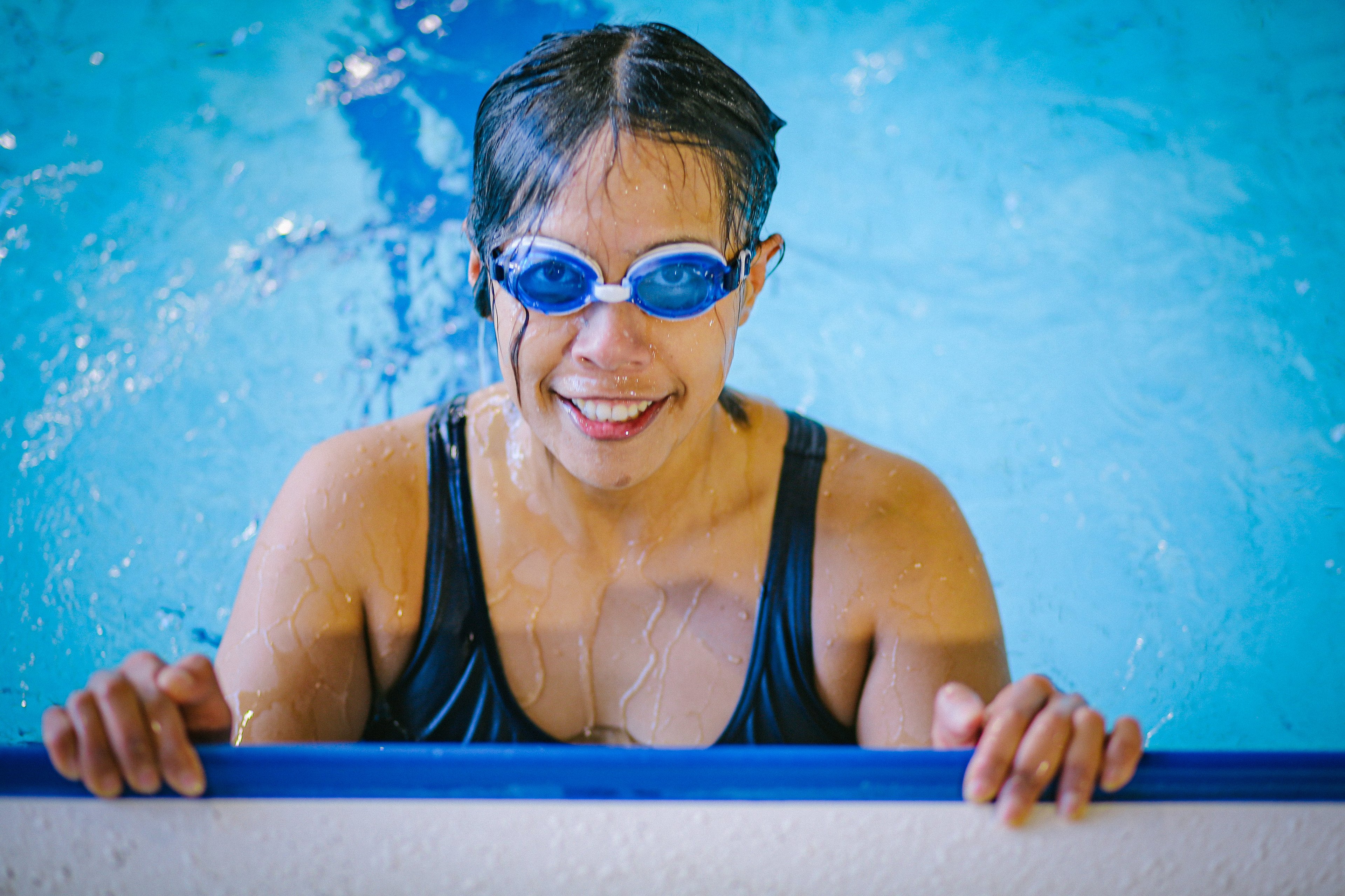 Woman wearing goggles and smiling in the pool at Cook + Phillip Park Pool