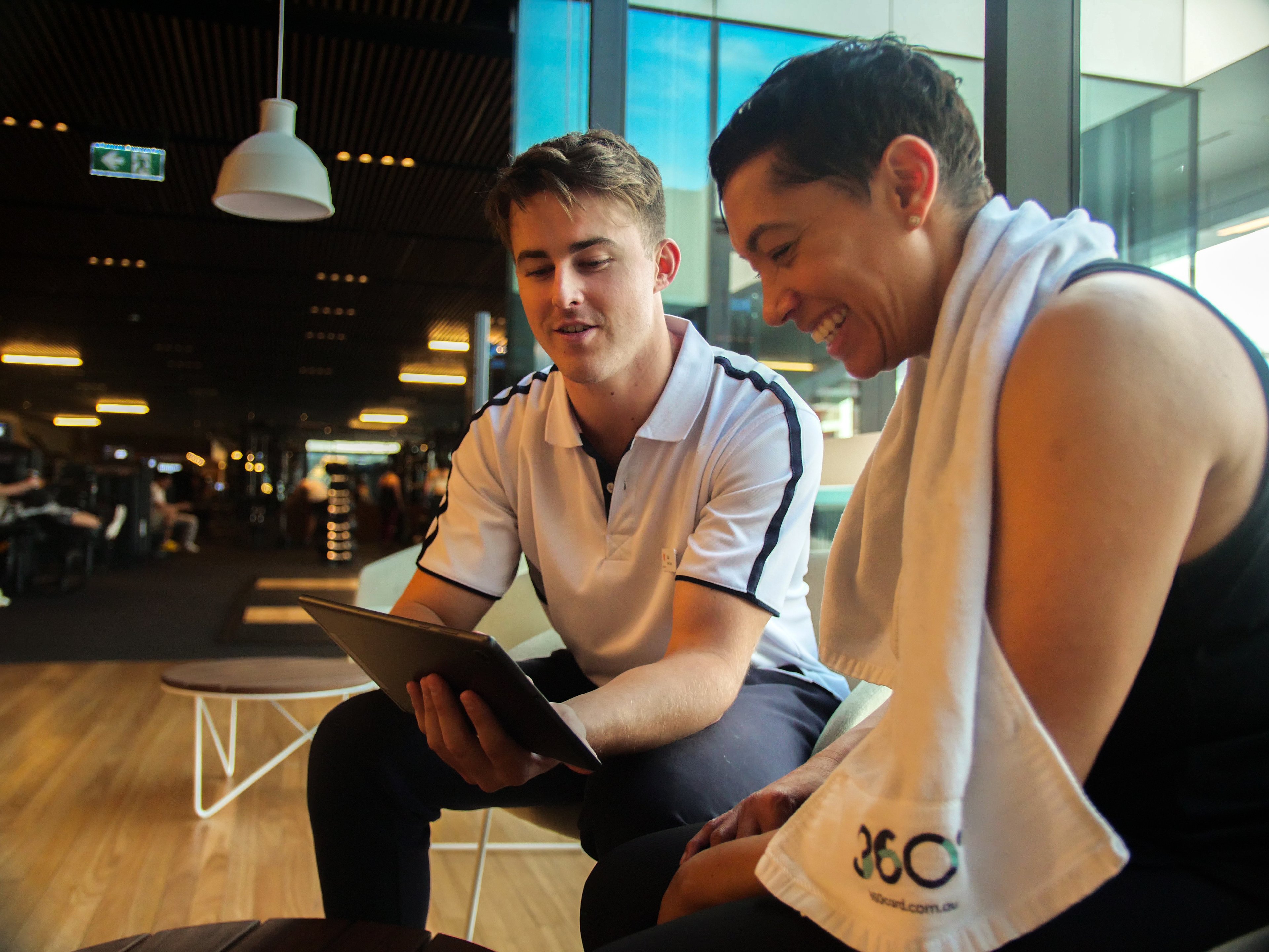 An exercise professional sitting with a client during a health consultation at Gunyama Park gym