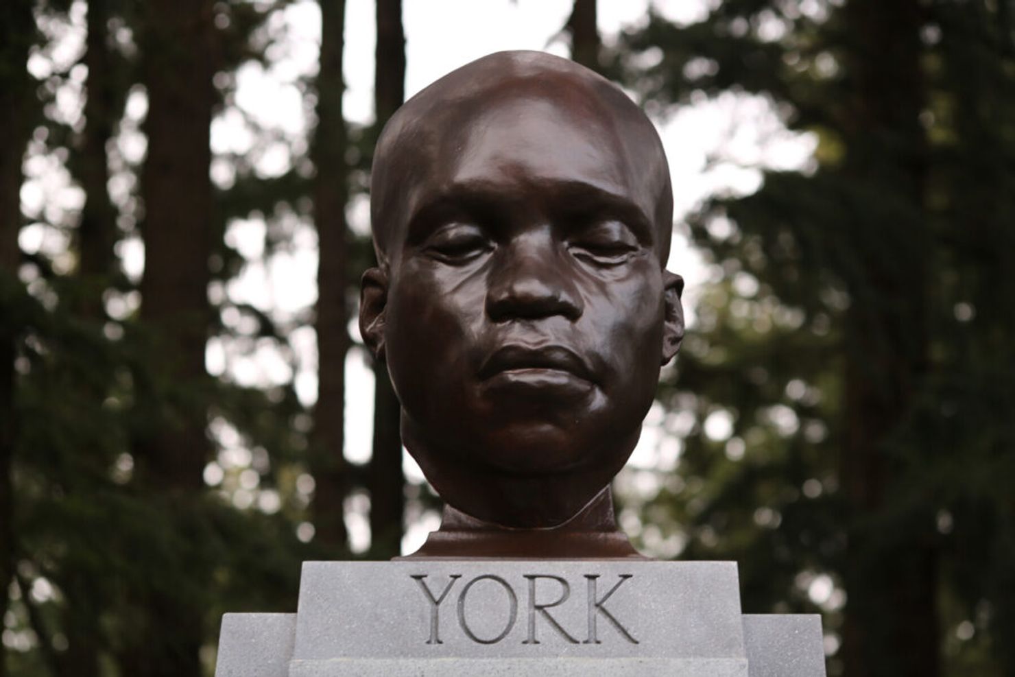A bust of York surrounded by shady trees.