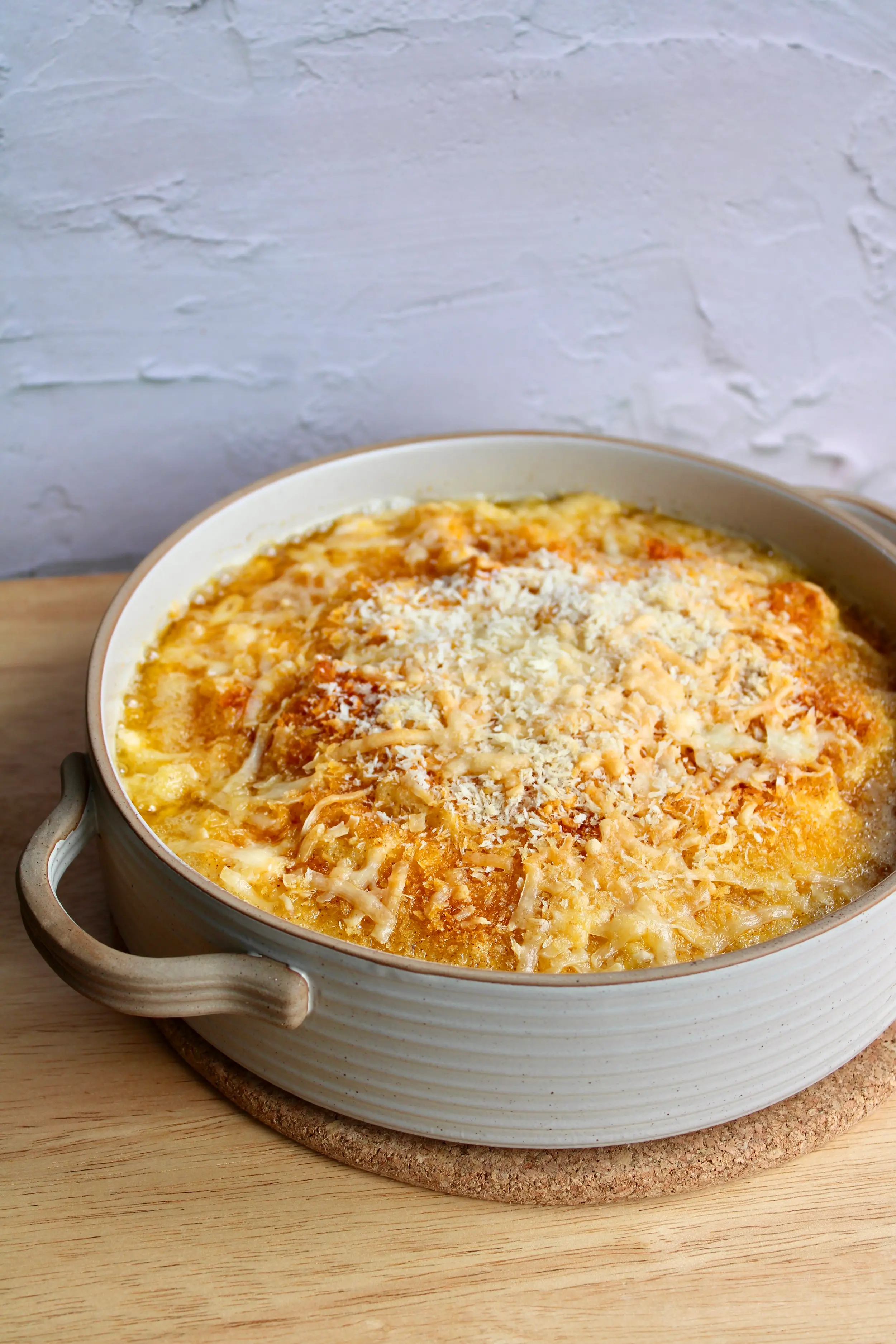 A large pot of creamy Mac n cheese with multiple types of shredded and cheese melted on top. 