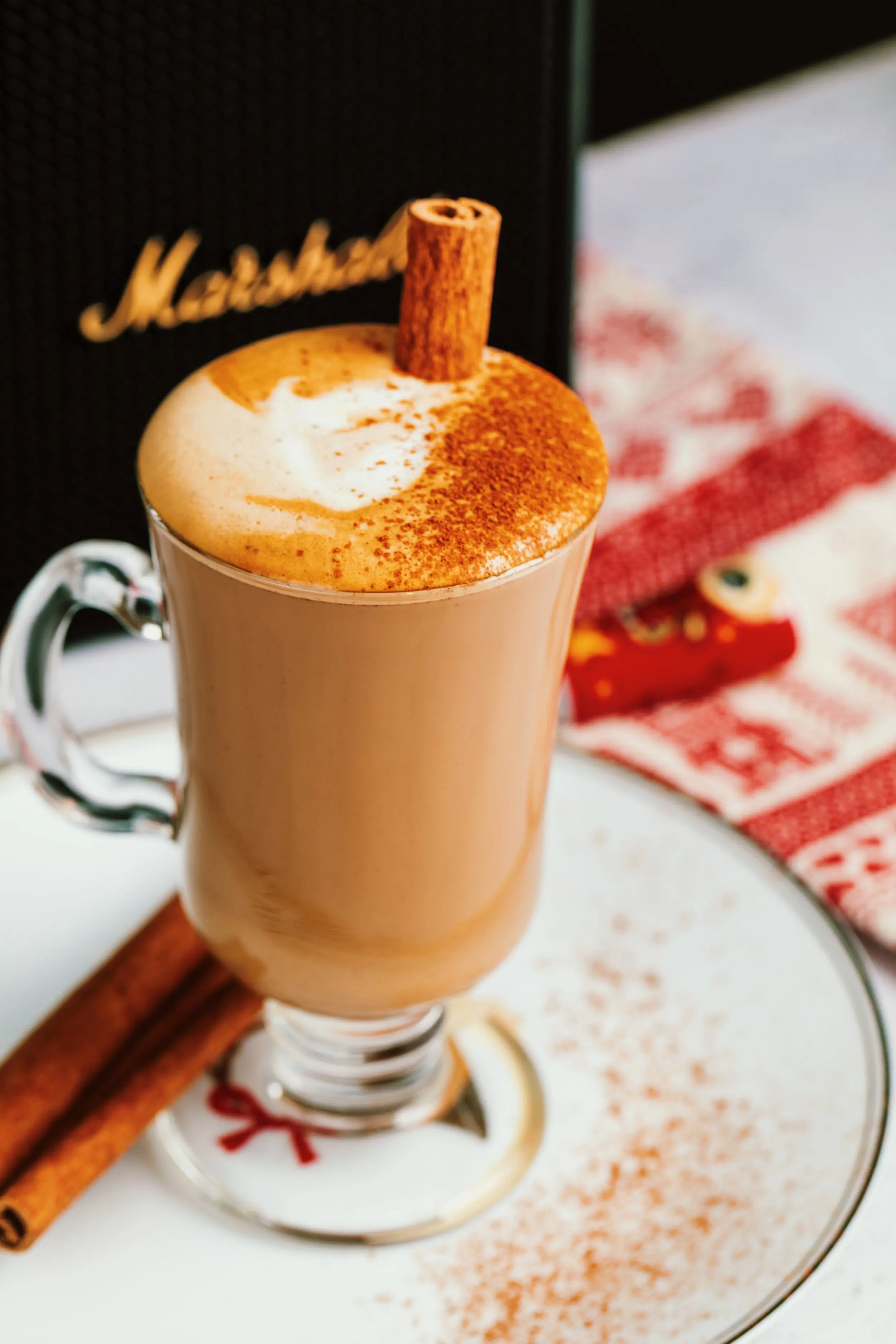 An orange cinnamon dolce latte with a cinnamon stick sticking out of the glass.