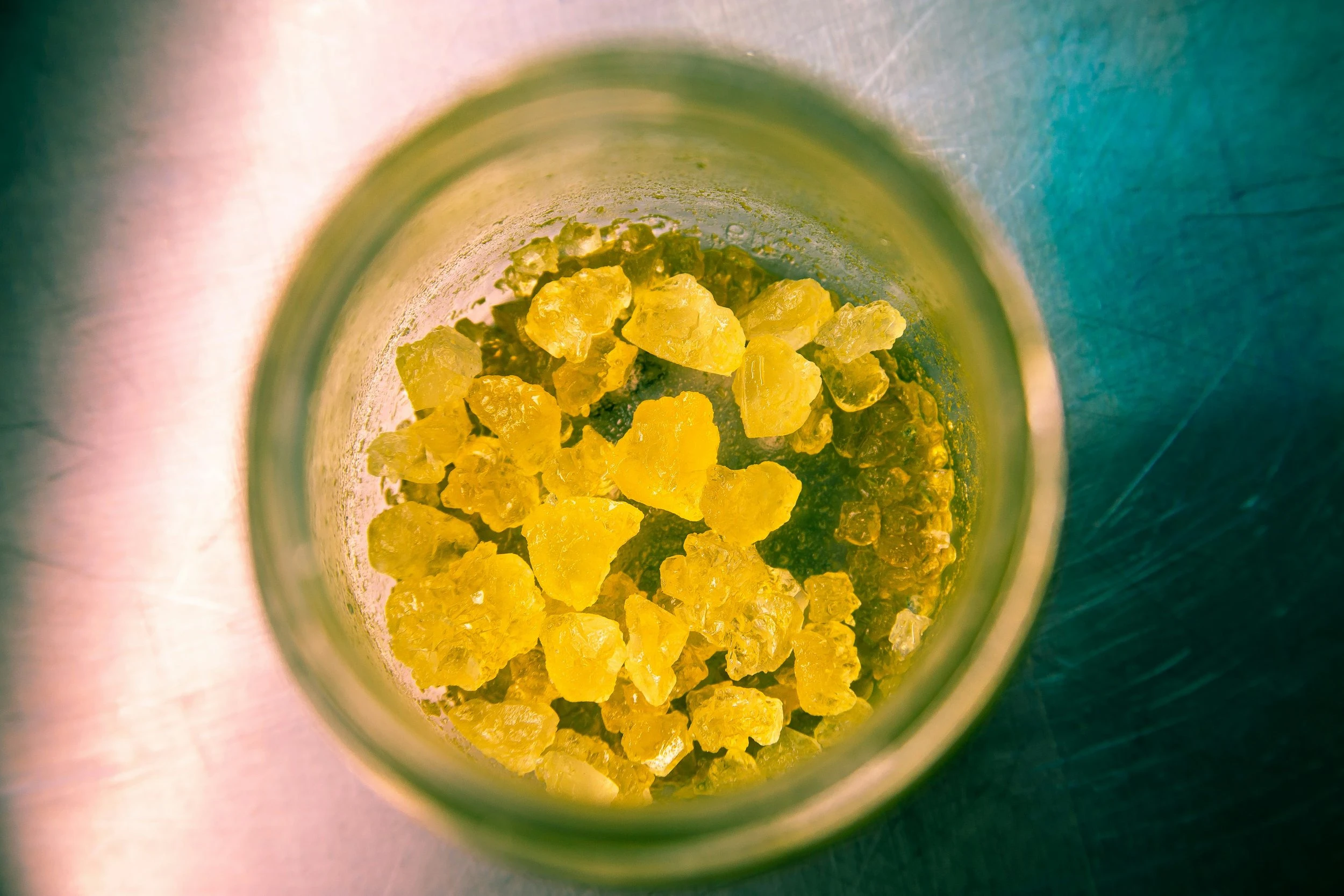 An overhead shot of some cannabis rock concentrates resting on a metal table.