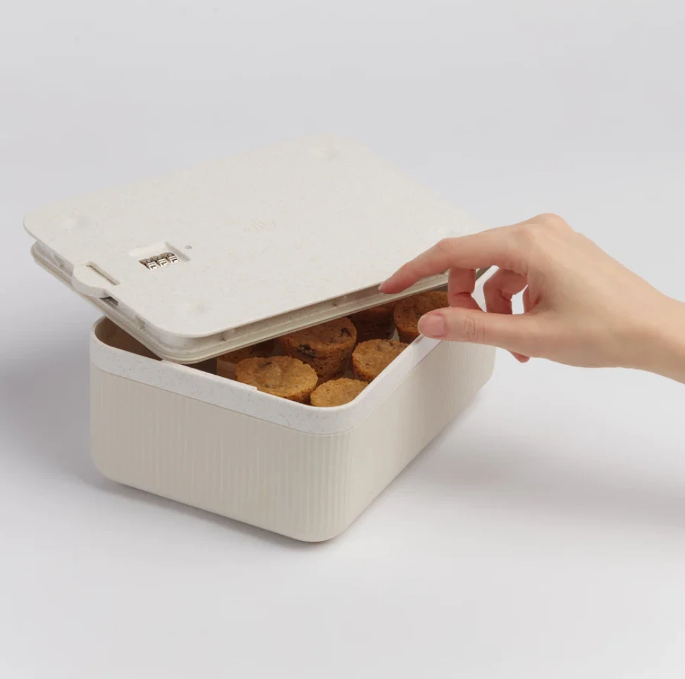 A cream coloured storage box that is partly open to feature a few sealed jars. 