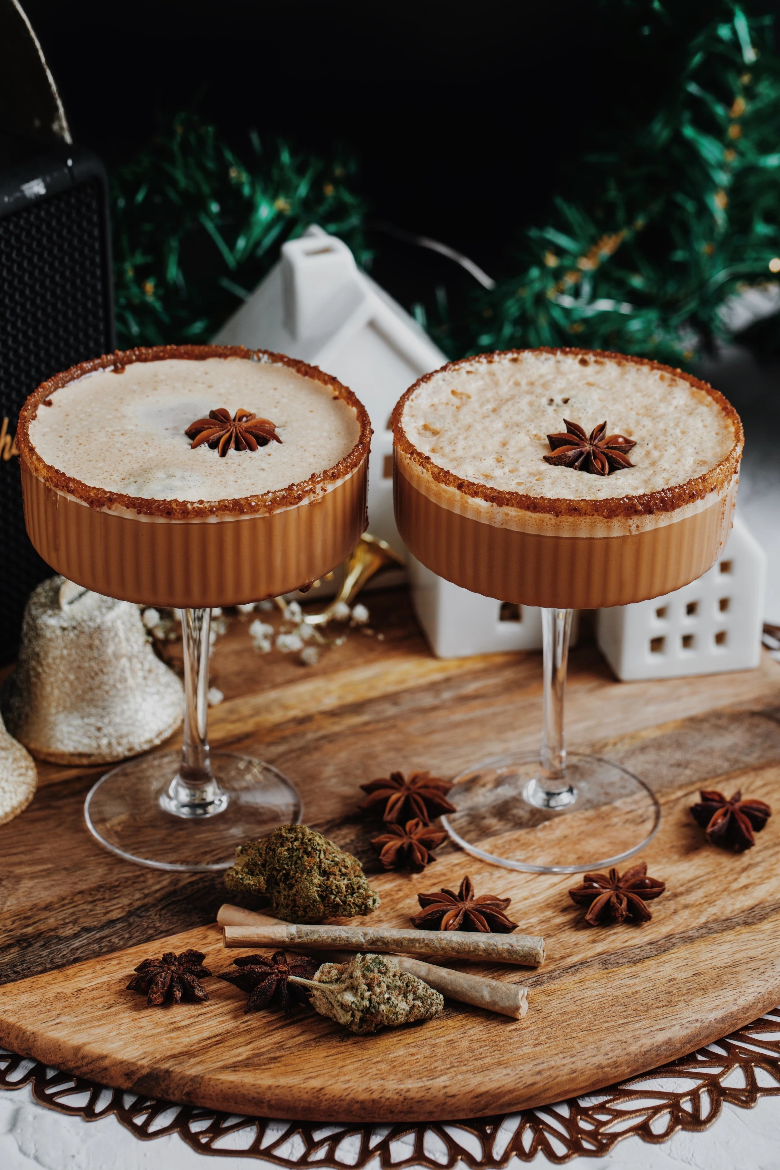 Two martini glasses holding a cannabis infused dirty chai espresso martini mocktail which is topped with a star anise on each beverage. 