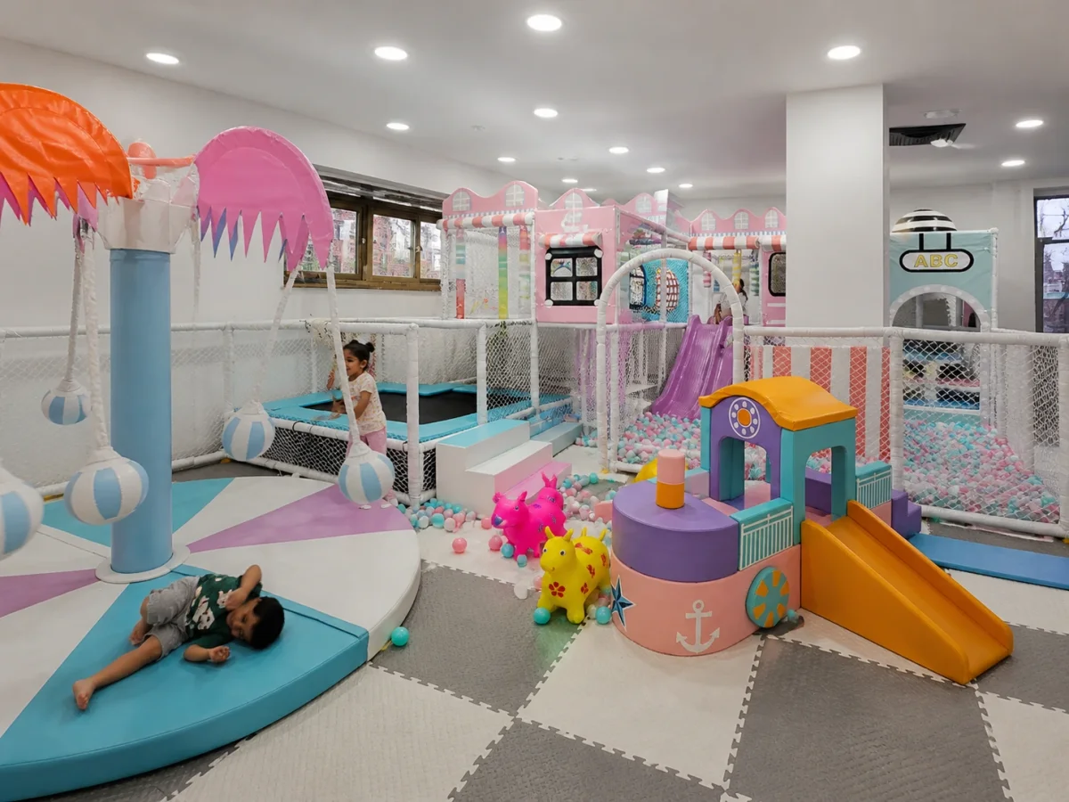 Pastel indoor soft play space with toddler-friendly slides, ball play and enclosed movement zones | Partyfer