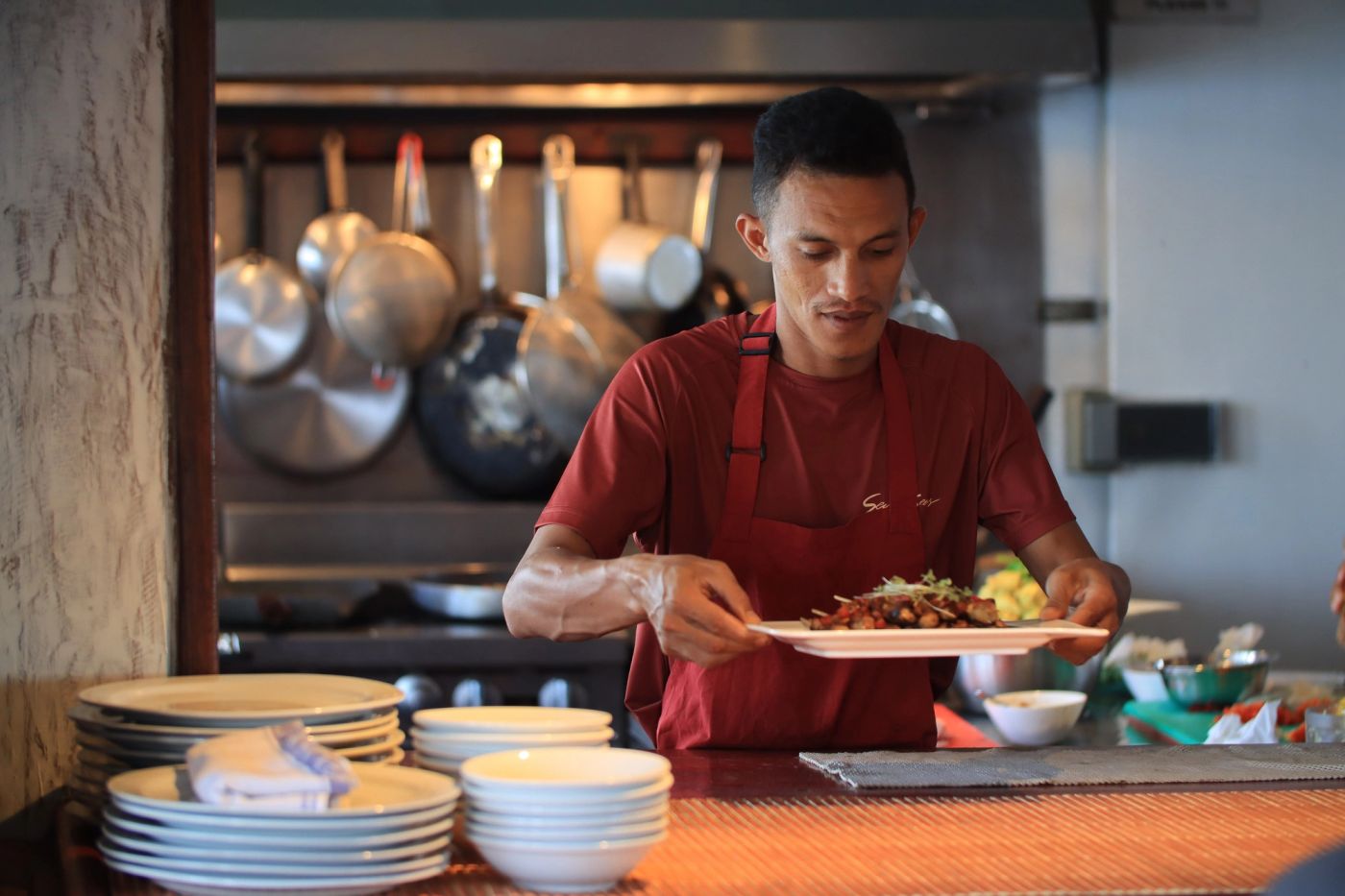 A chef carrying finished plates through a yacht galley