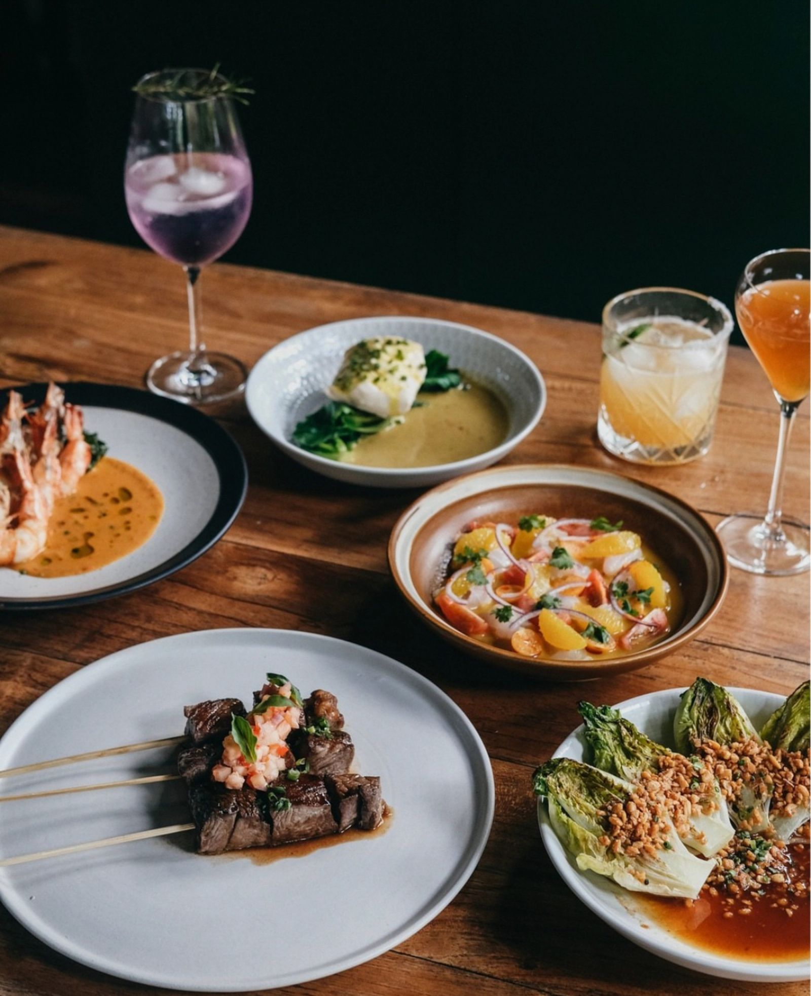Plates of food and drinks set on a wooden table