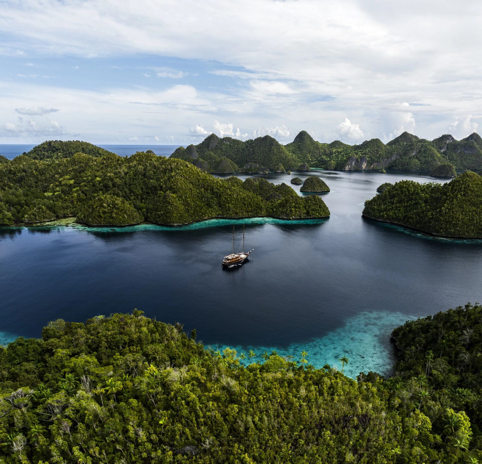 Vela at anchor among the karst islands of Wayag, from the air