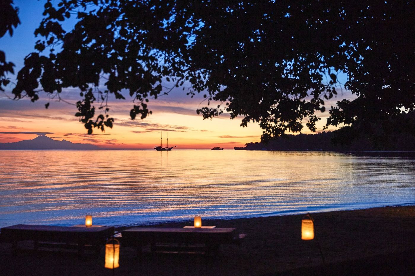 A lantern-lit beach dinner at dusk