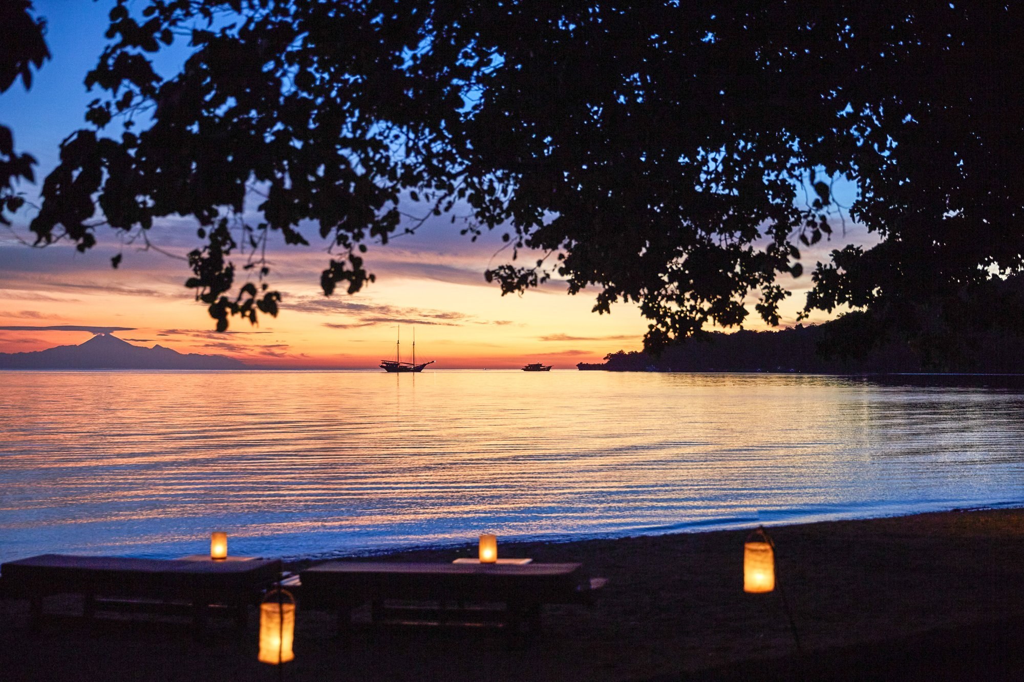 A lantern-lit beach dinner at dusk