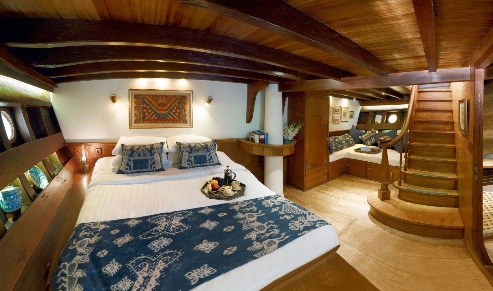 A suite aboard Si Datu Bua with a double bed and timber panelling