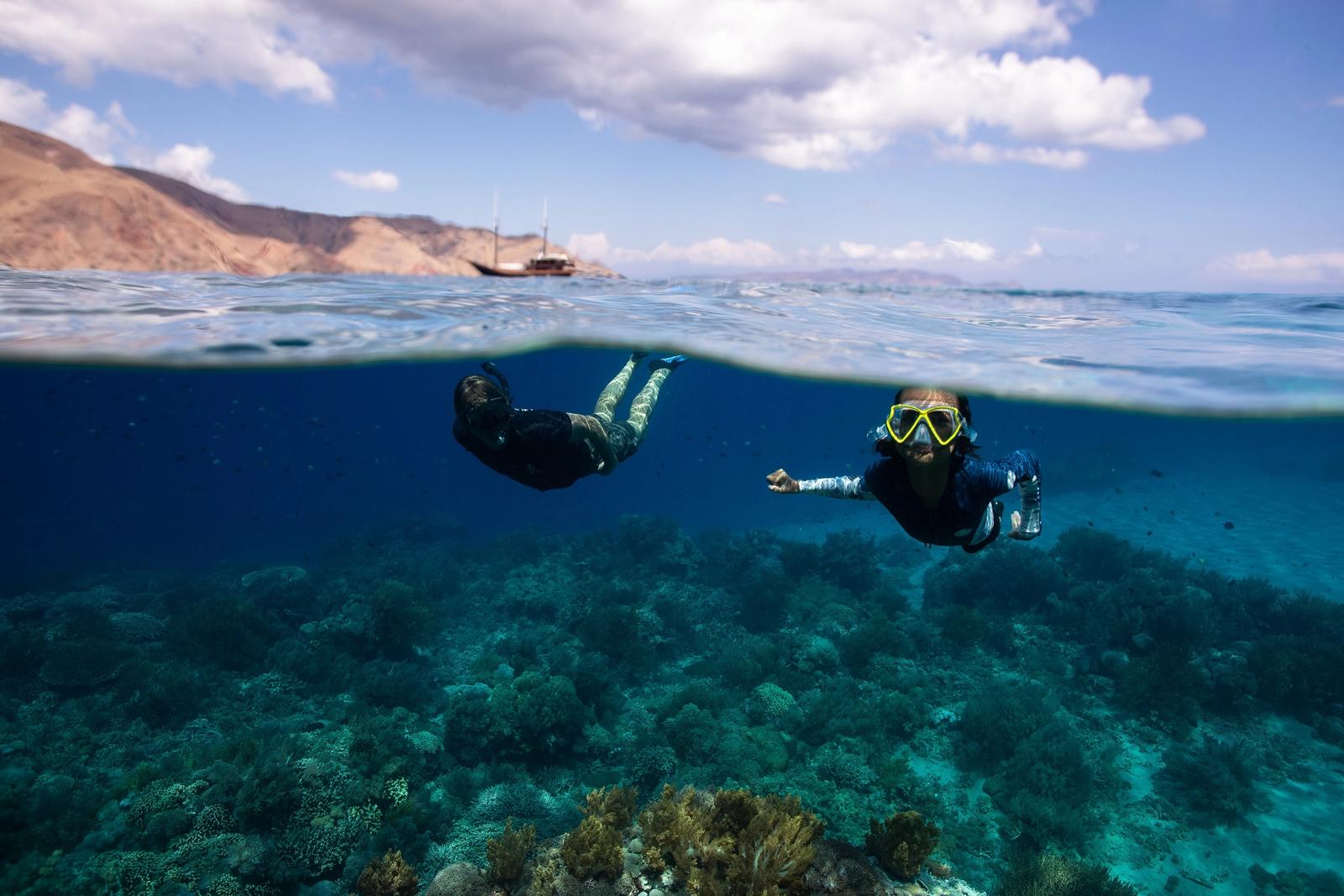 A family snorkels together straight off the yacht.