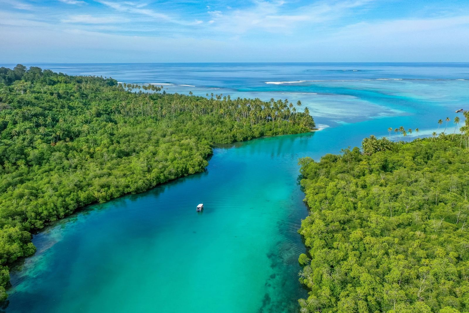 A flat green channel threads between forested islands, the sheltered water that defines the Telos.