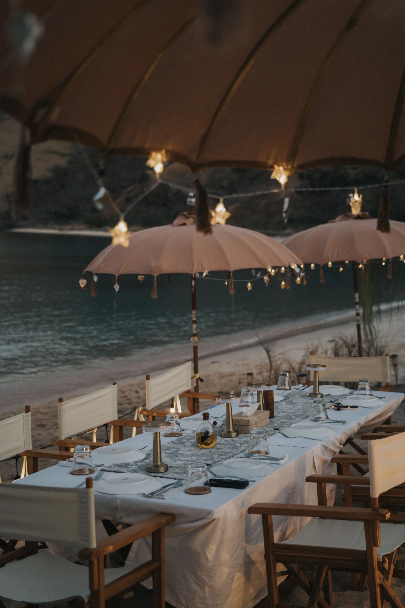 A lantern-lit beach dinner with Celestia offshore