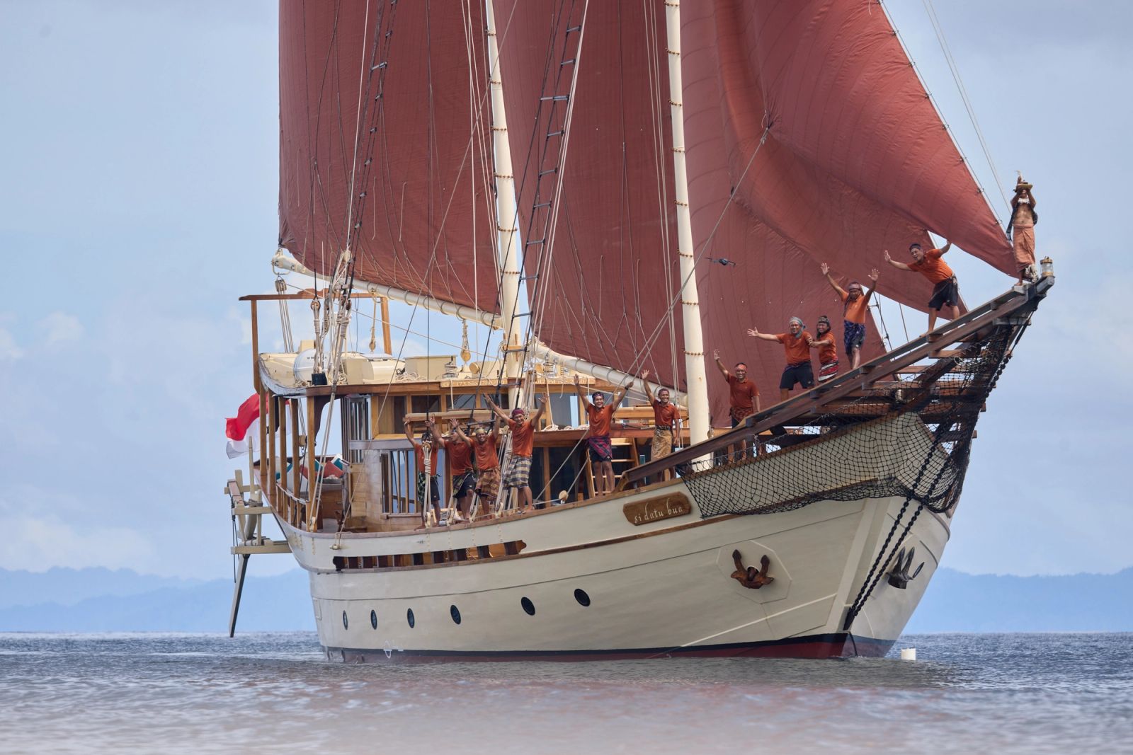 Si Datu Bua's crew in the rigging under red sails