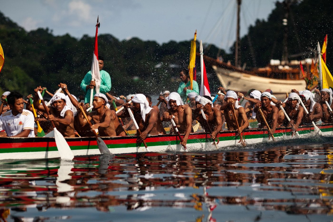 Kora kora canoes paddling out to meet the yacht in the Banda Islands