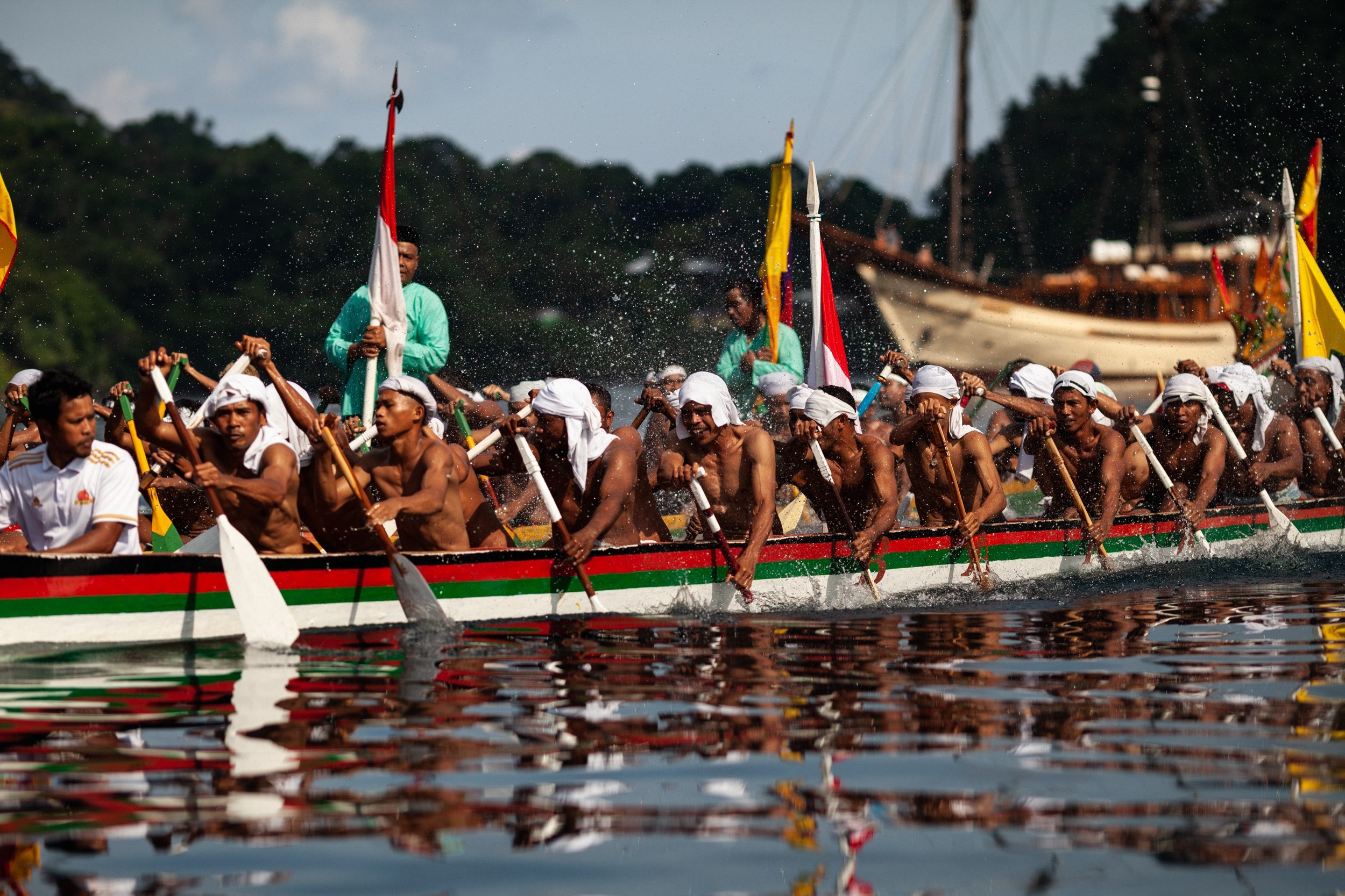 Kora kora canoes paddling out to meet the yacht in the Banda Islands
